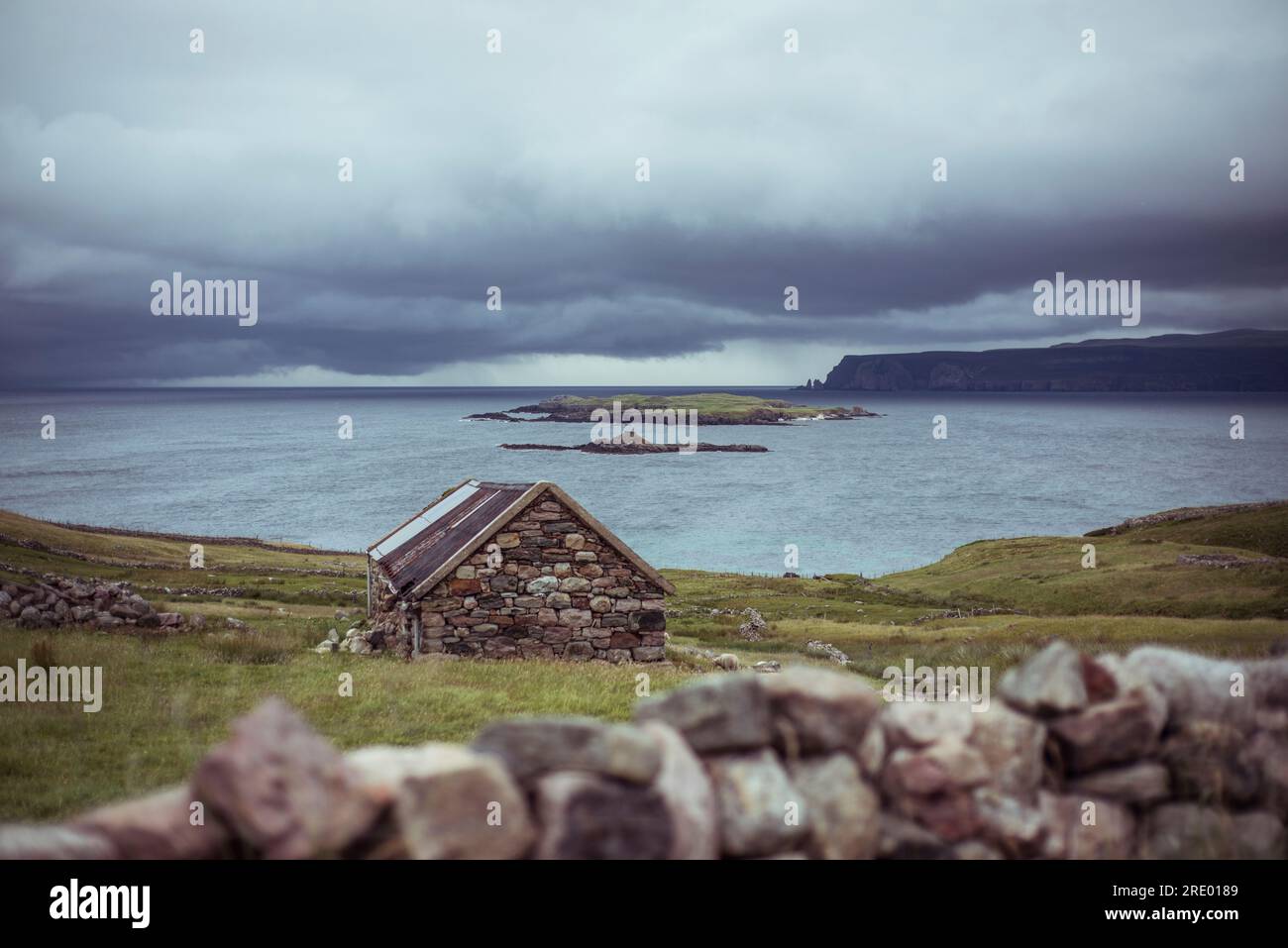 Cabane en pierre se trouve sur la côte isolée avec des falaises et des nuages Banque D'Images