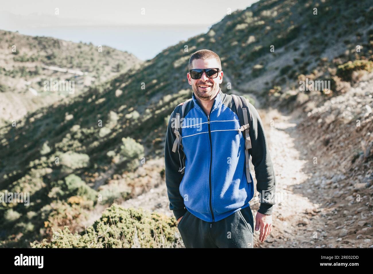 Jeune homme en lunettes de soleil souriant à la caméra dans les montagnes à Malaga Espagne Banque D'Images