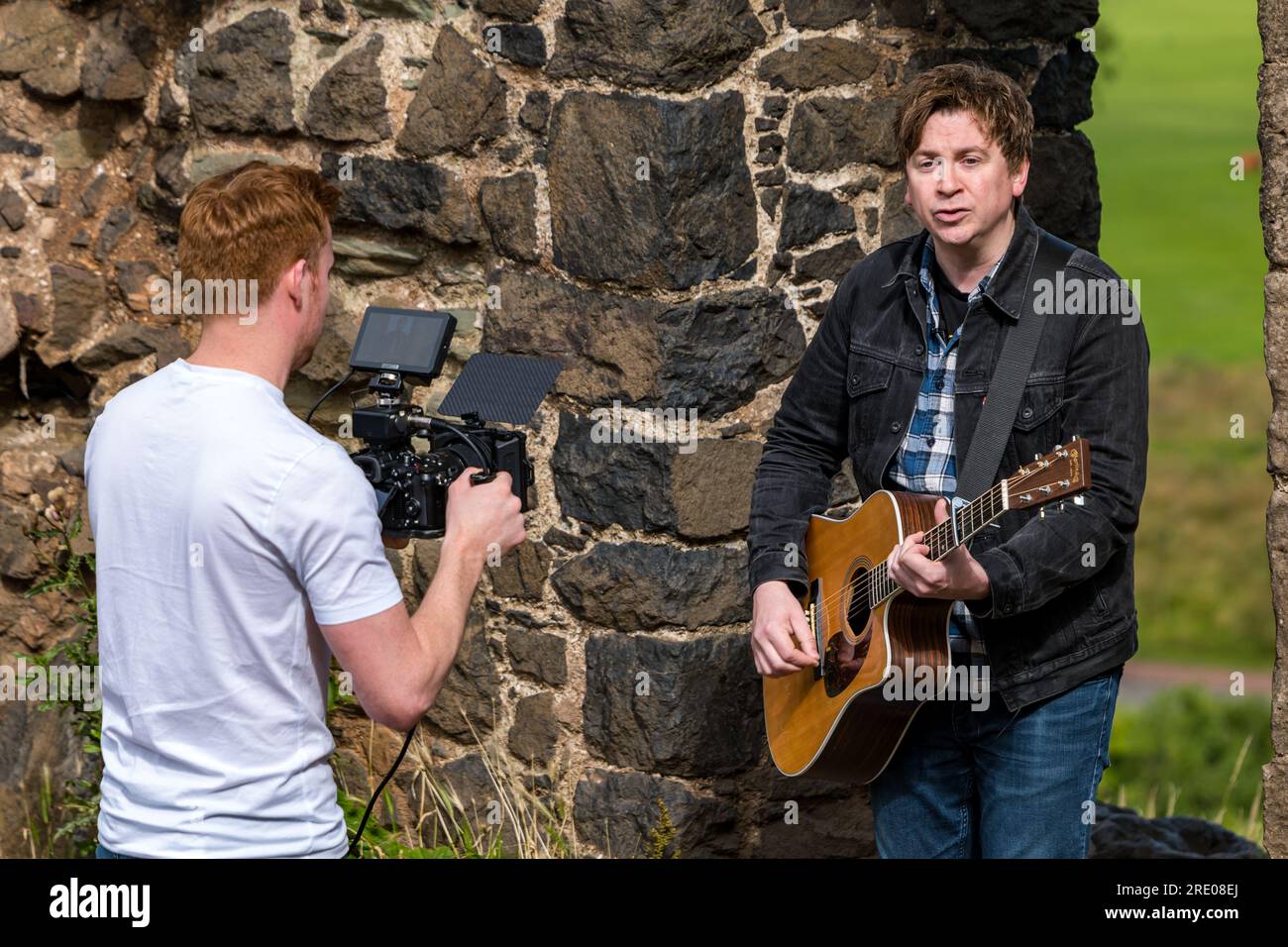 St Anthony's Chapel Holyrood Park, Édimbourg, Écosse, Royaume-Uni, 24 juillet 2023. Clip de Mike Baillie pour Fringe show : le chanteur du groupe The Lonely Together filme un nouveau clip pour son premier show Fringe Endless Sunset Oblivion qui raconte l'histoire d'un jeune compositeur Reuben qui tente de combattre les problèmes accélérés auxquels le monde est confronté. La chanson dans la vidéo a été écrite à cet endroit. Crédit : Sally Anderson/Alamy Live News Banque D'Images