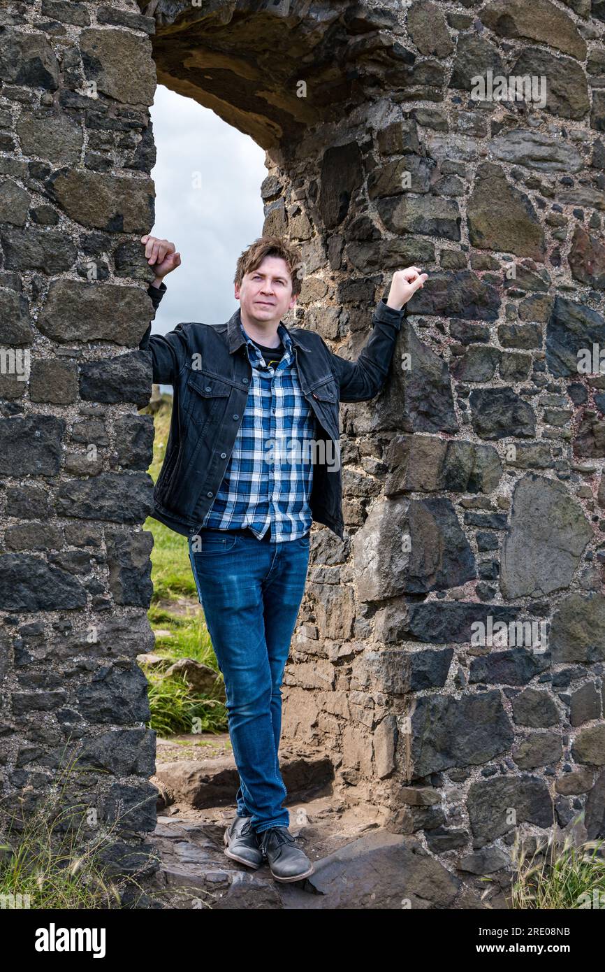 St Anthony's Chapel Holyrood Park, Édimbourg, Écosse, Royaume-Uni, 24 juillet 2023. Clip de Mike Baillie pour Fringe show : le chanteur du groupe The Lonely Together filme un nouveau clip pour son premier show Fringe Endless Sunset Oblivion qui raconte l'histoire d'un jeune compositeur Reuben qui tente de combattre les problèmes accélérés auxquels le monde est confronté. La chanson dans la vidéo a été écrite à cet endroit. Crédit : Sally Anderson/Alamy Live News Banque D'Images