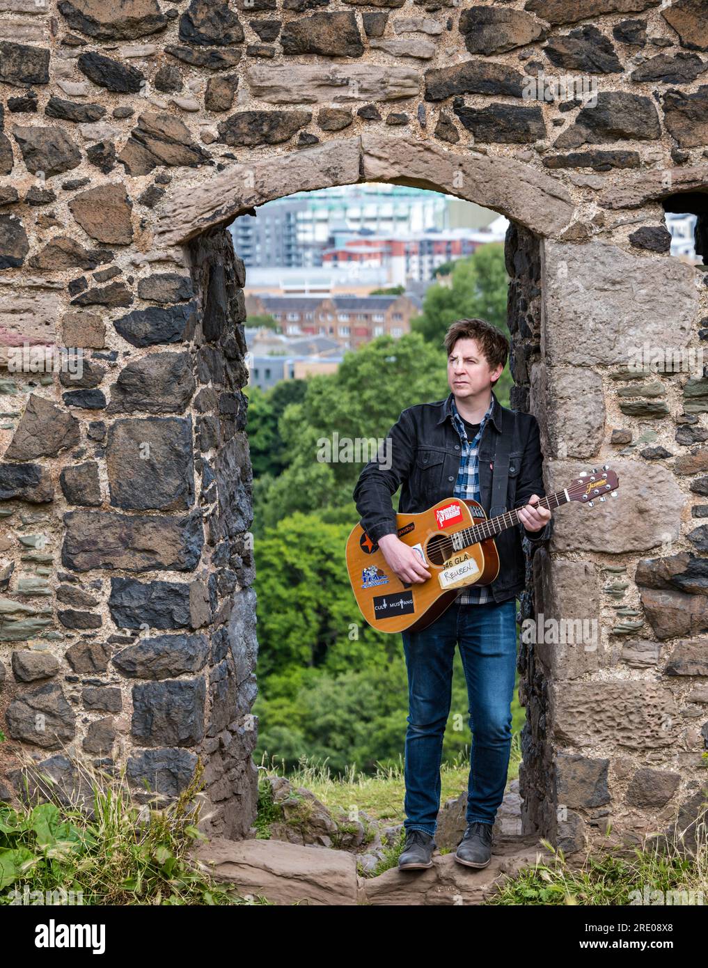 St Anthony's Chapel Holyrood Park, Édimbourg, Écosse, Royaume-Uni, 24 juillet 2023. Clip de Mike Baillie pour Fringe show : le chanteur du groupe The Lonely Together filme un nouveau clip pour son premier show Fringe Endless Sunset Oblivion qui raconte l'histoire d'un jeune compositeur Reuben qui tente de combattre les problèmes accélérés auxquels le monde est confronté. La chanson dans la vidéo a été écrite à cet endroit. Crédit : Sally Anderson/Alamy Live News Banque D'Images