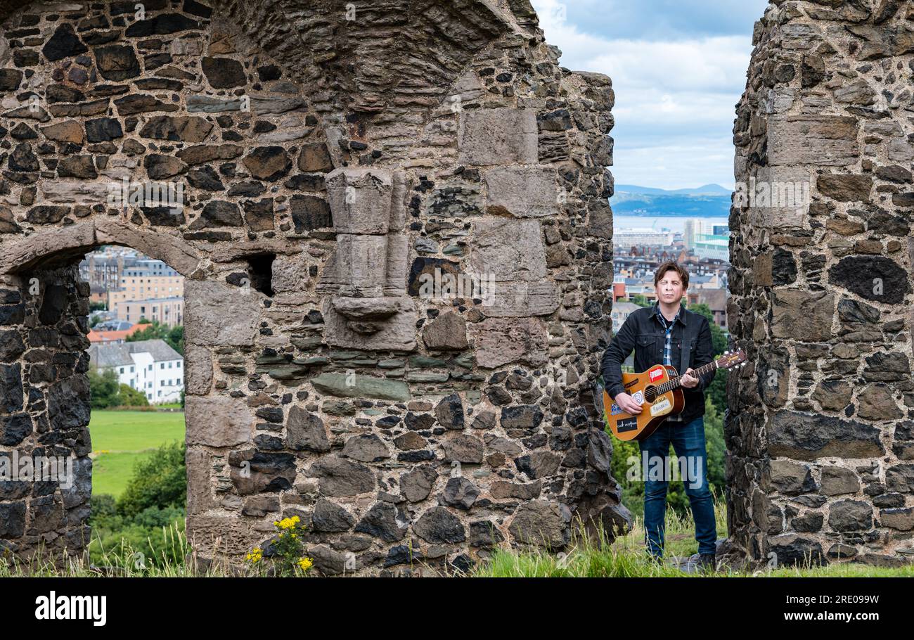 St Anthony's Chapel Holyrood Park, Édimbourg, Écosse, Royaume-Uni, 24 juillet 2023. Clip de Mike Baillie pour Fringe show : le chanteur du groupe The Lonely Together filme un nouveau clip pour son premier show Fringe Endless Sunset Oblivion qui raconte l'histoire d'un jeune compositeur Reuben qui tente de combattre les problèmes accélérés auxquels le monde est confronté. La chanson dans la vidéo a été écrite à cet endroit. Crédit : Sally Anderson/Alamy Live News Banque D'Images