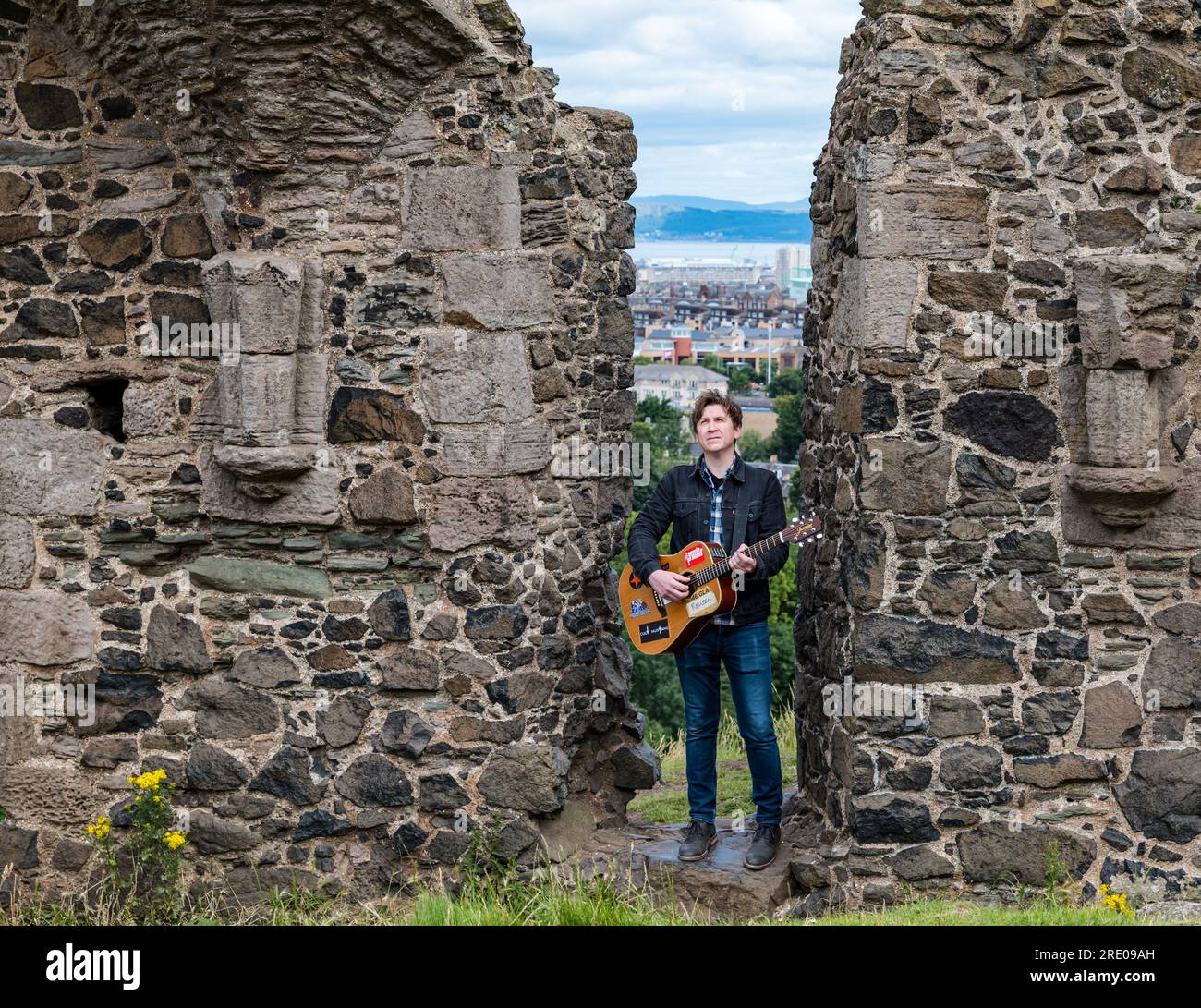 St Anthony's Chapel Holyrood Park, Édimbourg, Écosse, Royaume-Uni, 24 juillet 2023. Clip de Mike Baillie pour Fringe show : le chanteur du groupe The Lonely Together filme un nouveau clip pour son premier show Fringe Endless Sunset Oblivion qui raconte l'histoire d'un jeune compositeur Reuben qui tente de combattre les problèmes accélérés auxquels le monde est confronté. La chanson dans la vidéo a été écrite à cet endroit. Crédit : Sally Anderson/Alamy Live News Banque D'Images