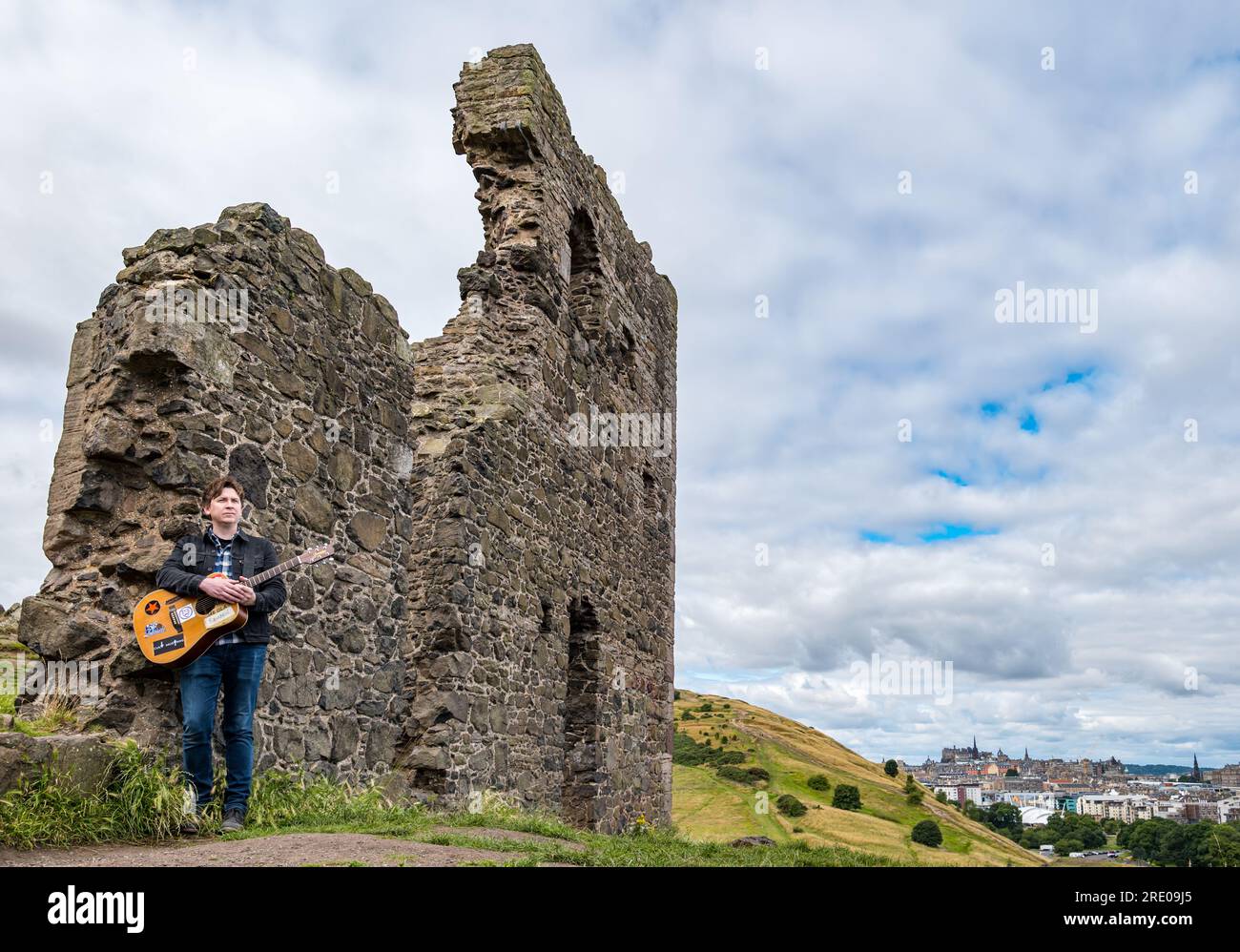 St Anthony's Chapel Holyrood Park, Édimbourg, Écosse, Royaume-Uni, 24 juillet 2023. Clip de Mike Baillie pour Fringe show : le chanteur du groupe The Lonely Together filme un nouveau clip pour son premier show Fringe Endless Sunset Oblivion qui raconte l'histoire d'un jeune compositeur Reuben qui tente de combattre les problèmes accélérés auxquels le monde est confronté. La chanson dans la vidéo a été écrite à cet endroit. Crédit : Sally Anderson/Alamy Live News Banque D'Images