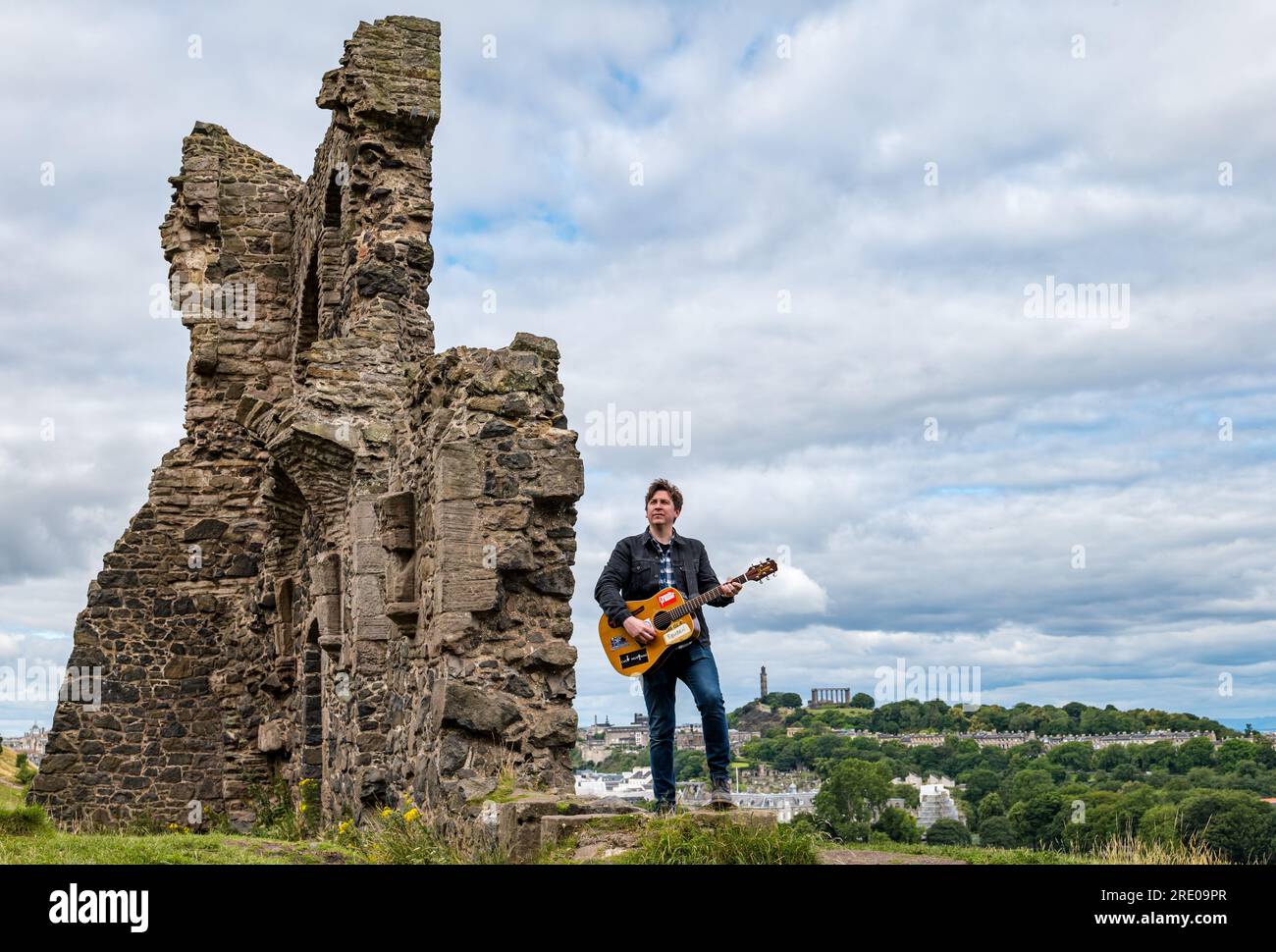 St Anthony's Chapel Holyrood Park, Édimbourg, Écosse, Royaume-Uni, 24 juillet 2023. Clip de Mike Baillie pour Fringe show : le chanteur du groupe The Lonely Together filme un nouveau clip pour son premier show Fringe Endless Sunset Oblivion qui raconte l'histoire d'un jeune compositeur Reuben qui tente de combattre les problèmes accélérés auxquels le monde est confronté. La chanson dans la vidéo a été écrite à cet endroit. Crédit : Sally Anderson/Alamy Live News Banque D'Images