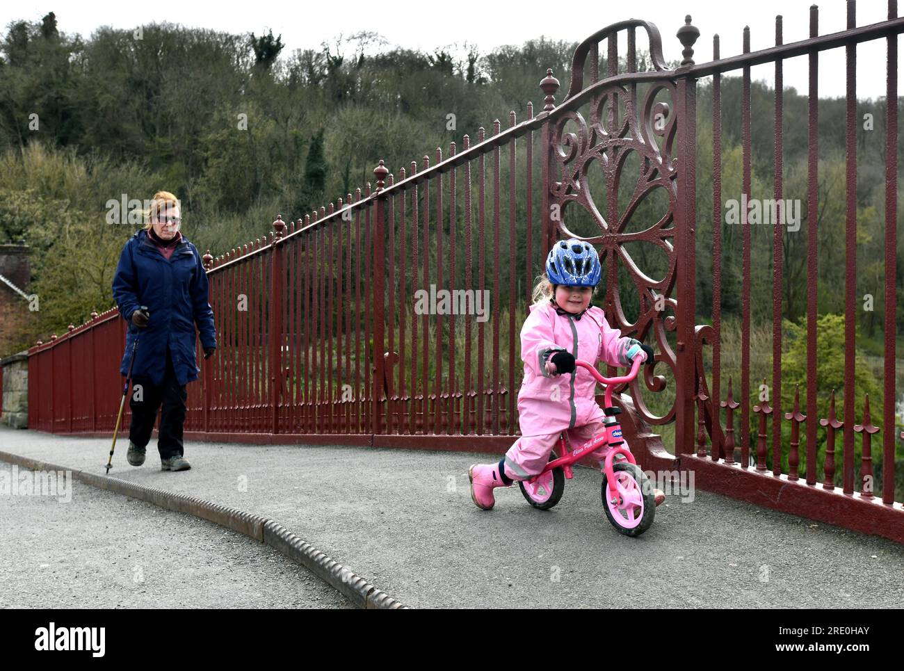 Enfant chevauchant le vélo d'équilibre rose sur le chemin de la Grande-Bretagne, Royaume-Uni Banque D'Images