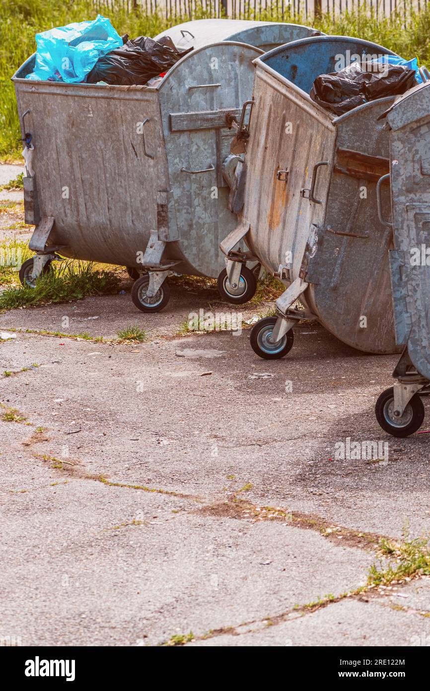 Conteneur à ordures métallique rempli de sacs à déchets en plastique dans la rue, mise au point sélective Banque D'Images
