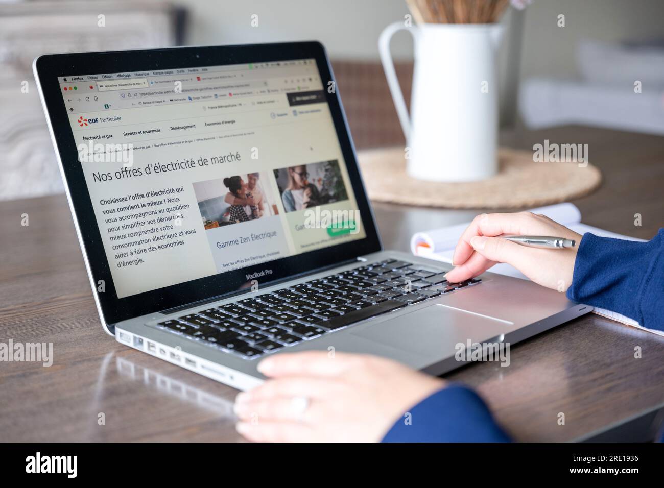 Femme lisant les offres d'électricité et de gaz sur le site Web d'un fournisseur d'énergie. A l'écran, le site Internet EDF (Office français de l'électricité) Banque D'Images