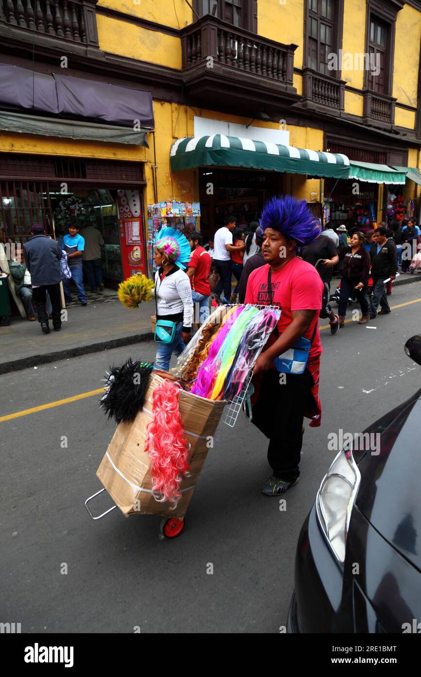 Homme vendant des perruques colorées pour Halloween dans la zone commerciale du centre de Lima, Pérou Banque D'Images