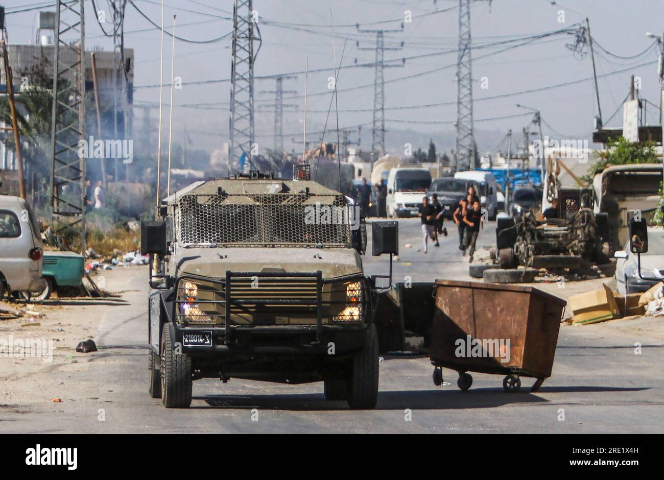 Nalus, Palestine. 24 juillet 2023. Des Palestiniens jettent des pierres sur des véhicules blindés militaires israéliens lors d’une opération militaire à l’intérieur du camp, à l’est de Naplouse, en Cisjordanie occupée. L ' armée israélienne a attaqué les camps de Nour Shams, à l ' est de Tulkarem, et Aqabat Jabr à Jéricho (Askar), à l ' est de Naplouse, au cours d ' une opération conjointe visant à arrêter les personnes recherchées. Crédit : SOPA Images Limited/Alamy Live News Banque D'Images