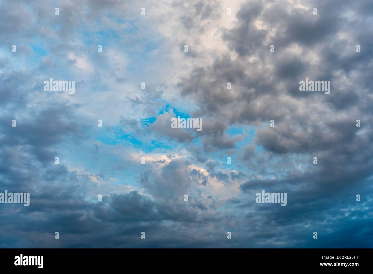 Des nuages incroyablement beaux avec un trou bleu. Ciel du soir après la pluie. Banque D'Images