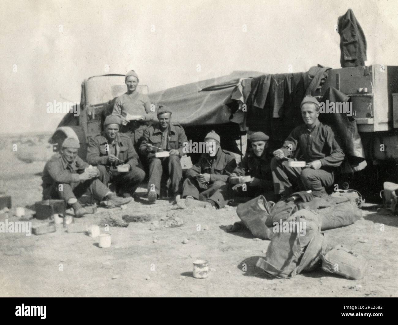 Libye. 1942. Des soldats britanniques mangeaient un repas dans des boîtes de conserve alors qu'ils étaient assis devant une paire de camions du modèle militaire canadien (CMP) près de MSU (Libye) en janvier 1942. La photographie a été prise pendant la campagne nord-africaine de la seconde Guerre mondiale. Banque D'Images Libye. 1942. Des soldats britanniques mangeaient un repas dans des boîtes de conserve alors qu'ils étaient assis devant une paire de camions du modèle militaire canadien (CMP) près de MSU (Libye) en janvier 1942. La photographie a été prise pendant la campagne nord-africaine de la seconde Guerre mondiale. Banque D'Images