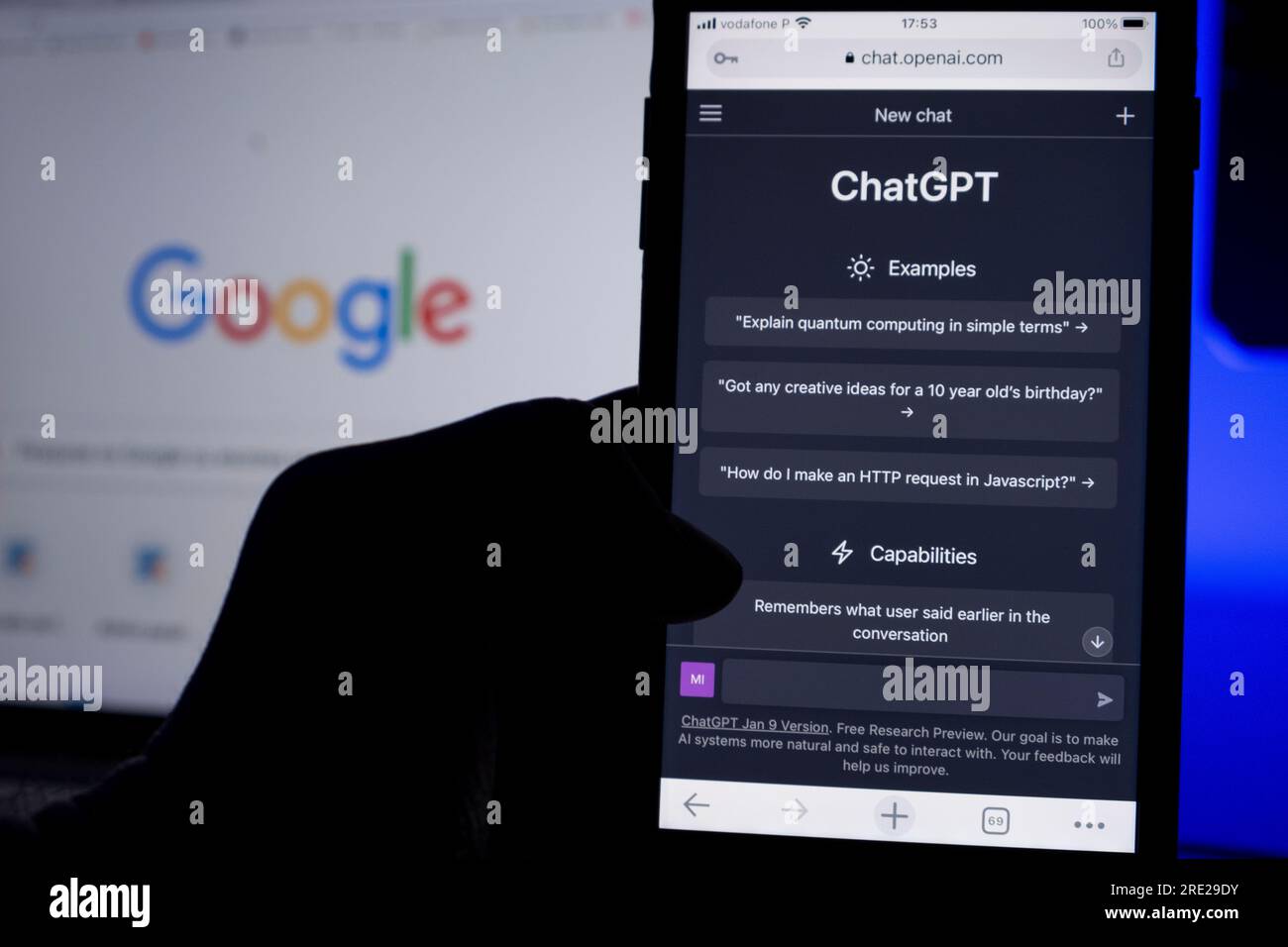Açores, Portugal - 16.01.2023 : téléphone portable à main levée avec ai ChatGPT page d'accueil. Développé par OpenAI. En arrière-plan, un écran d'ordinateur portable avec effet de flou artistique Banque D'Images