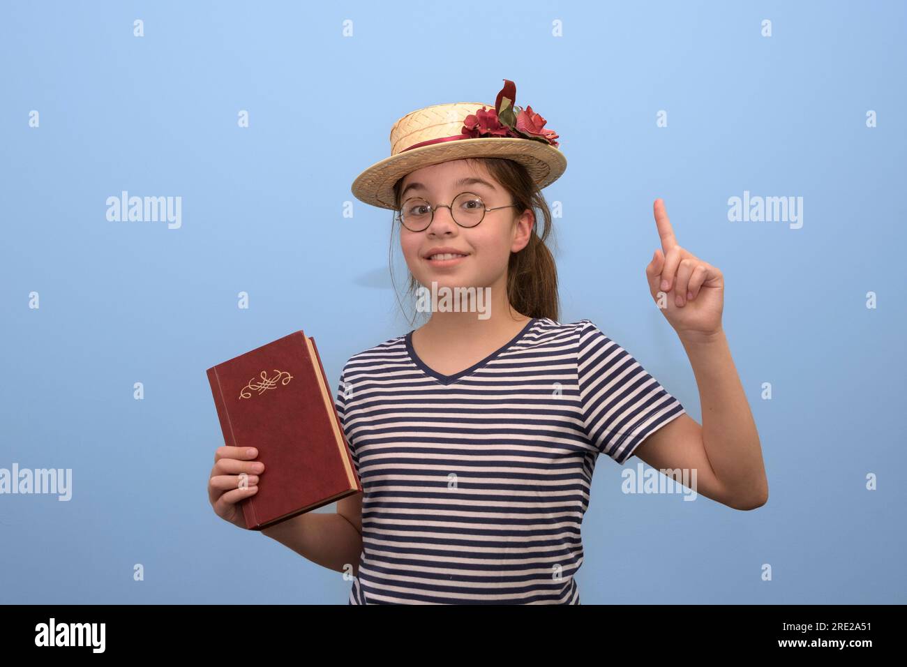 Une adolescente en costume du siècle dernier recommande la lecture de livres et de littérature classique. portrait de studio Banque D'Images