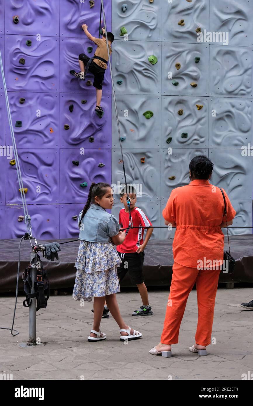 Kazakhstan, Almaty. Jeune garçon sur le mur d'escalade à Kok-Tobe Park. Banque D'Images