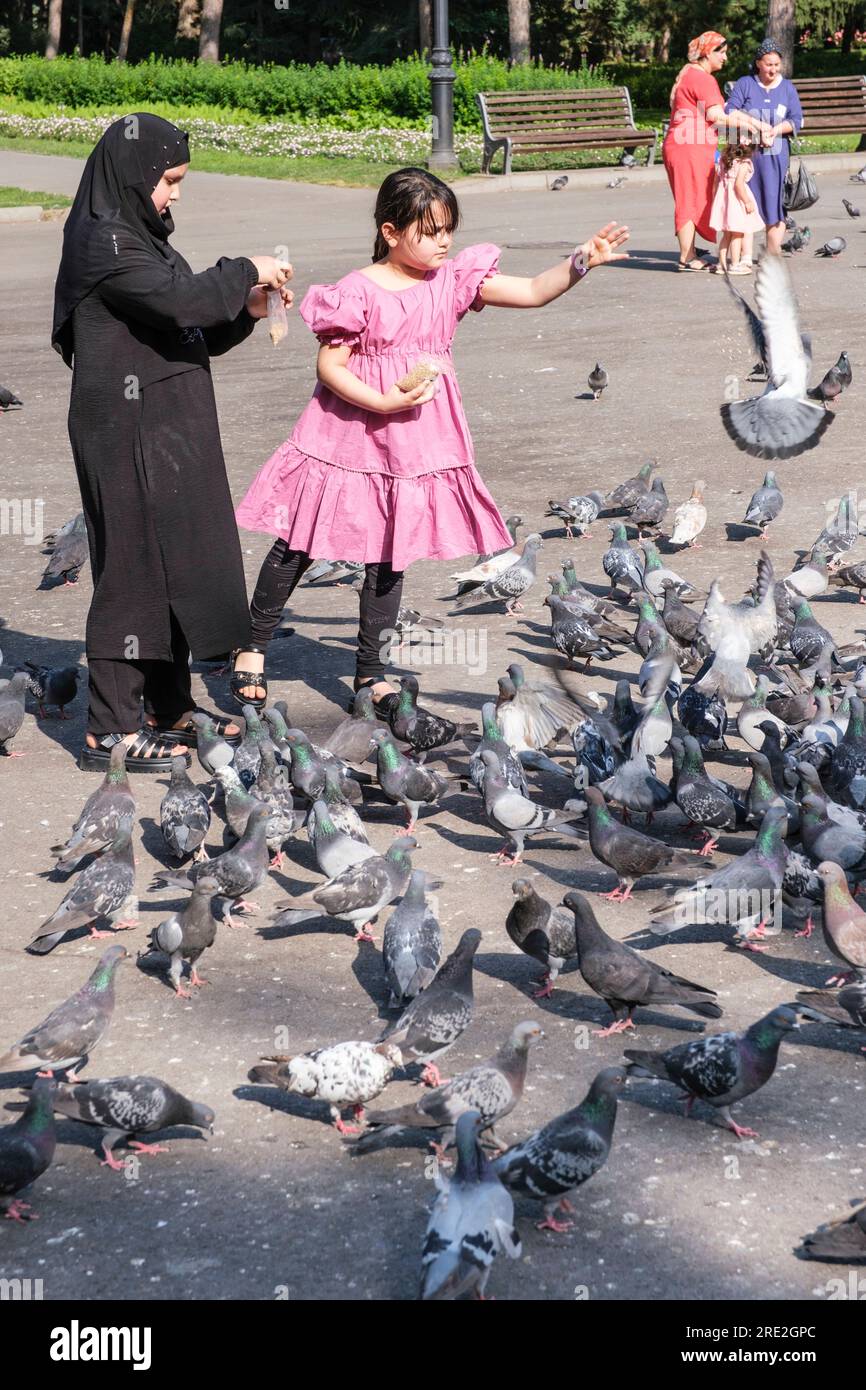 Kazakhstan, Almaty. Jeunes filles Feediung Pigeons devant la cathédrale de l'Ascension, orthodoxe russe. Banque D'Images