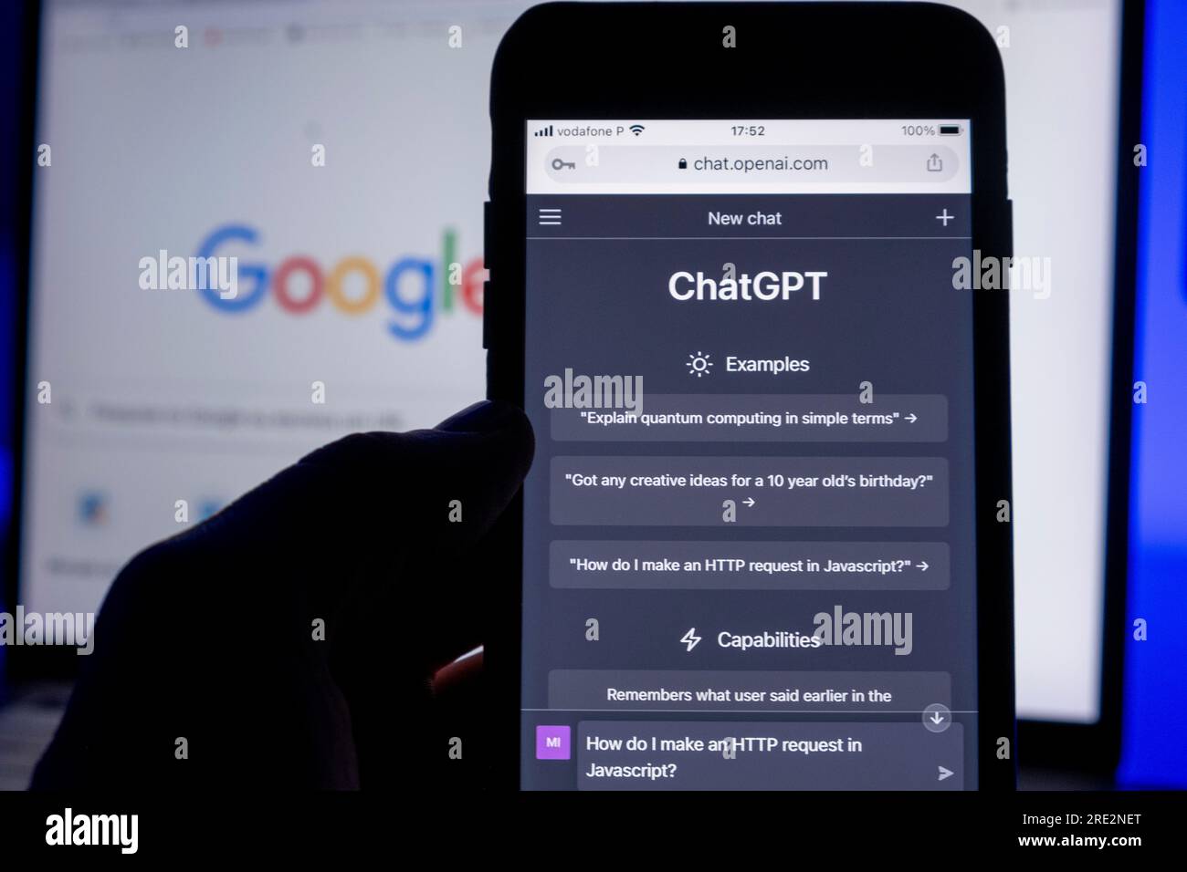 Açores, Portugal - 16.01.2023 : SmartPhon avec ai ChatGPT page d'accueil. Développé par OpenAI. En arrière-plan, un écran d'ordinateur portable avec Google Searc défocalisé Banque D'Images