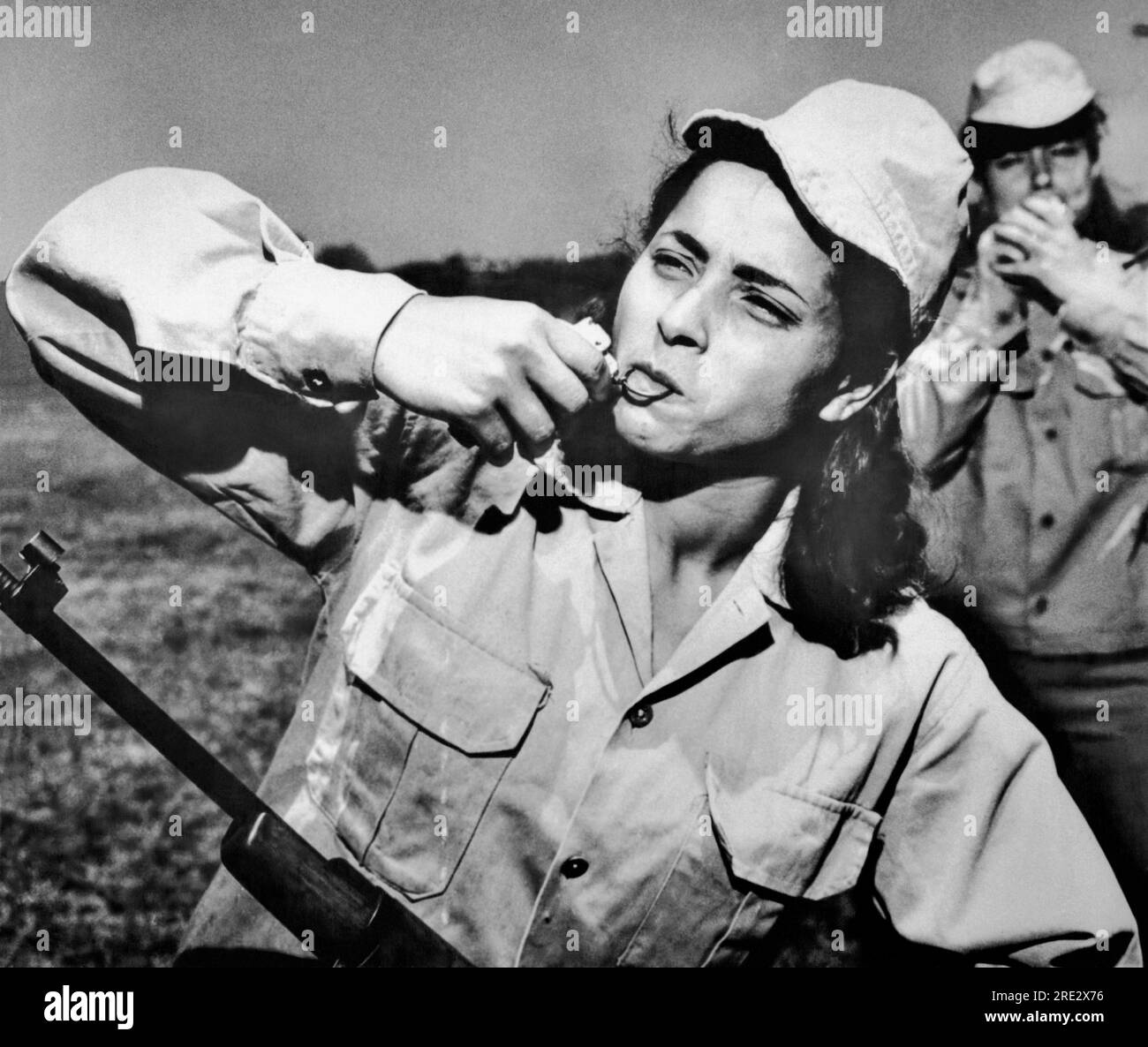 Le Caire, Egypte : 2 juin 1967 Une femme membre du Futewa, ou bataillons de la Garde Naitonale composé d'étudiants volontaires de l'UAR, tire la goupille d'une gernade de main avec ses dents pendant l'entraînement dans un camp. Au total, 113 bataillons Futewa seront formés au Caire et 30 autres à Alexandrie. Banque D'Images