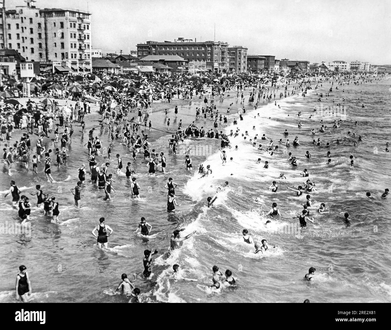 Santa Monica, Californie : décembre 1923. Foules de baigneurs du dimanche profitant des eaux chaudes de décembre de la côte Pacifique à Ocean Park Beach à Santa Monica. Banque D'Images