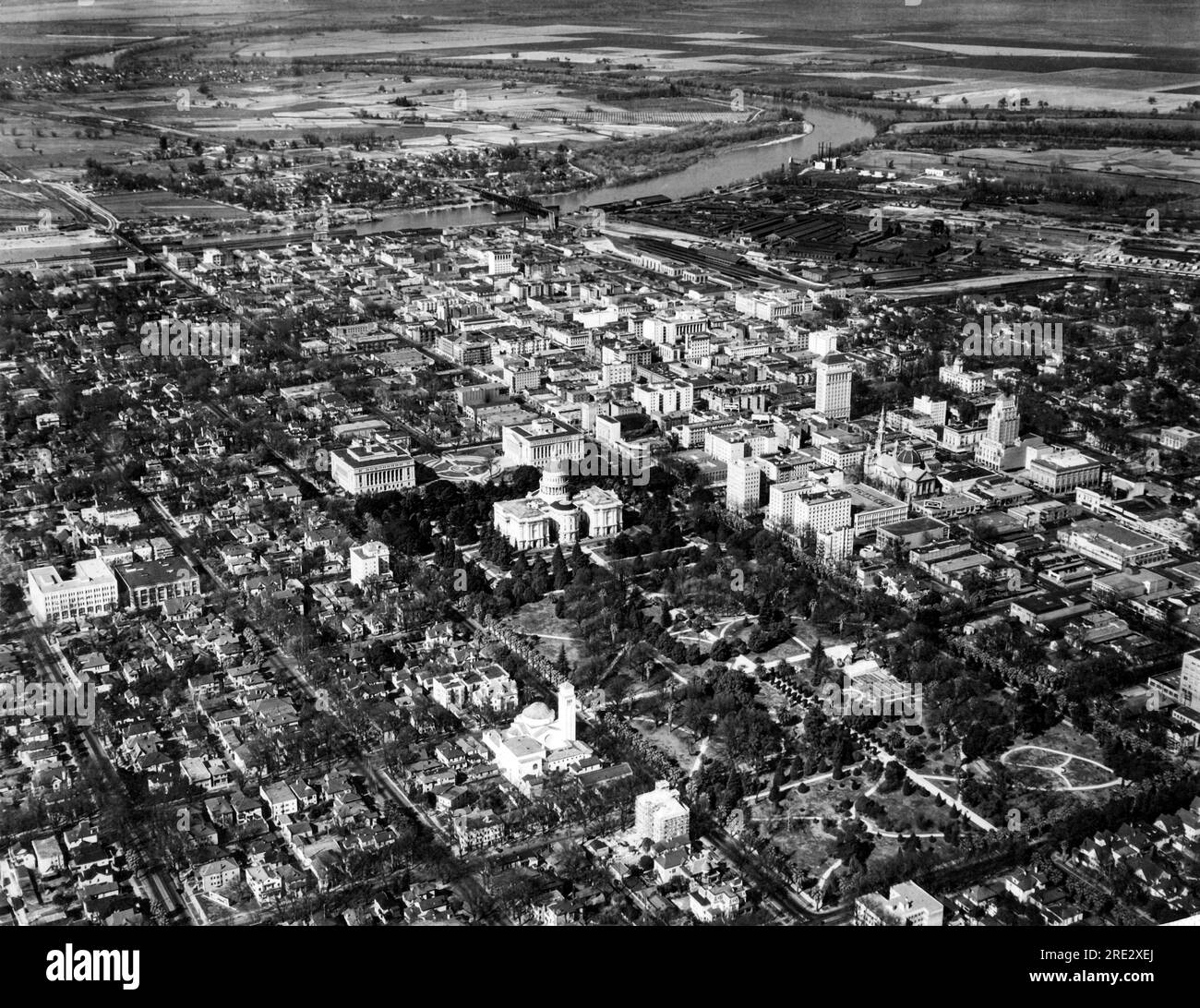 Sacramento, Californie, le 12 avril 1933 vue aérienne du Capitole de l'État de Californie entre les bâtiments Capitol Park et Capitol extension, les sections commerciales et industrielles et la rivière Sacramento. Banque D'Images