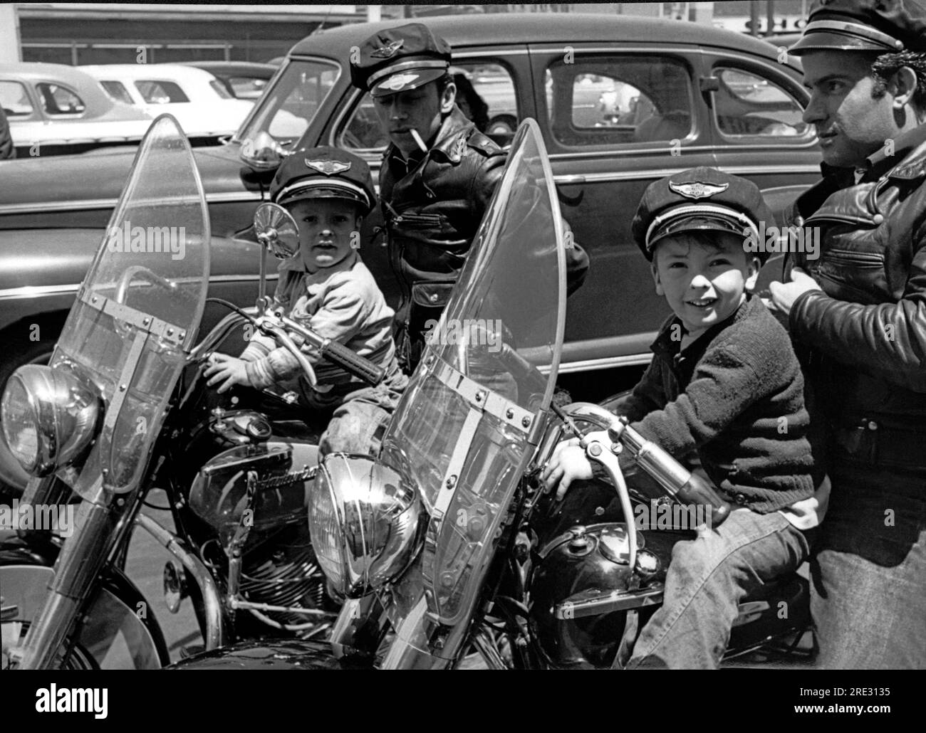 San Francisco, Californie vers 1954 deux motards portant des casquettes et des vestes en cuir sur leurs Harley Davidsons avec leurs petits fils devant eux. Les garçons portent des casquettes qui disent "Harley Davidson Motor cycle". Banque D'Images
