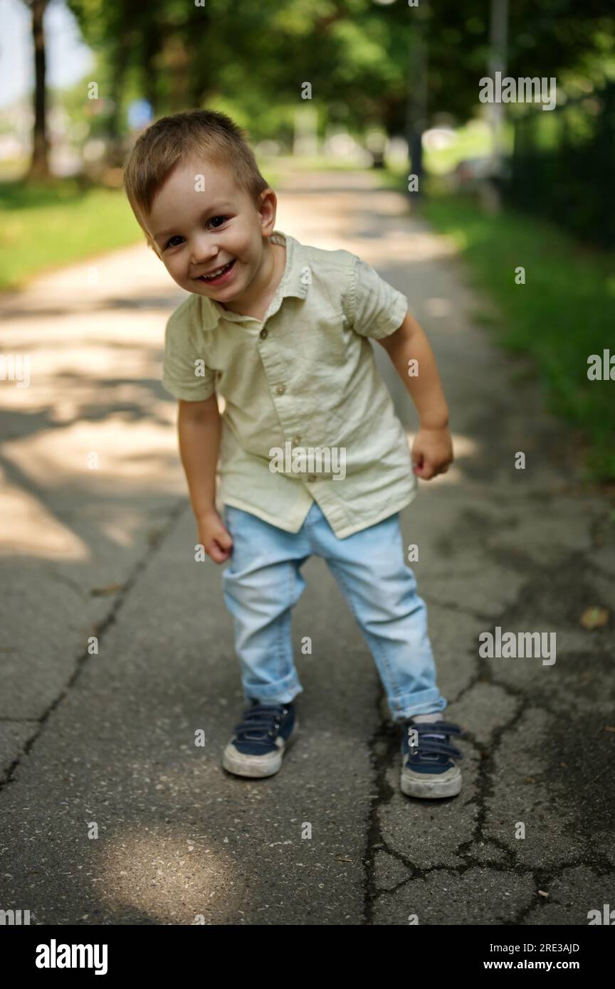 Portrait de petit enfant debout dans la rue et posant Banque D'Images