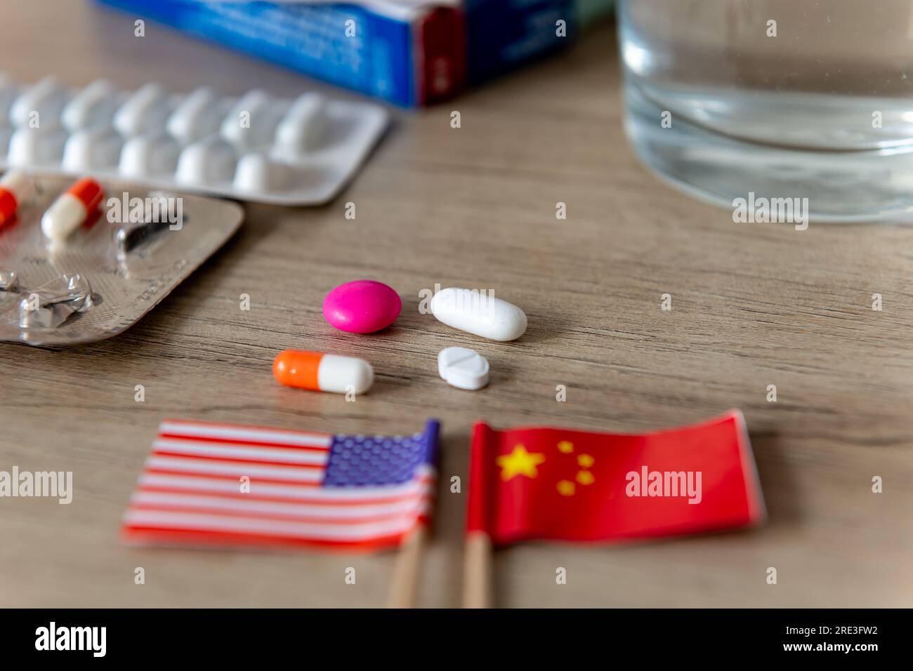 Une compétition pharmaceutique, médicale, conflit, concept avec les drapeaux américain et chinois et divers médicaments sur un bureau. Banque D'Images