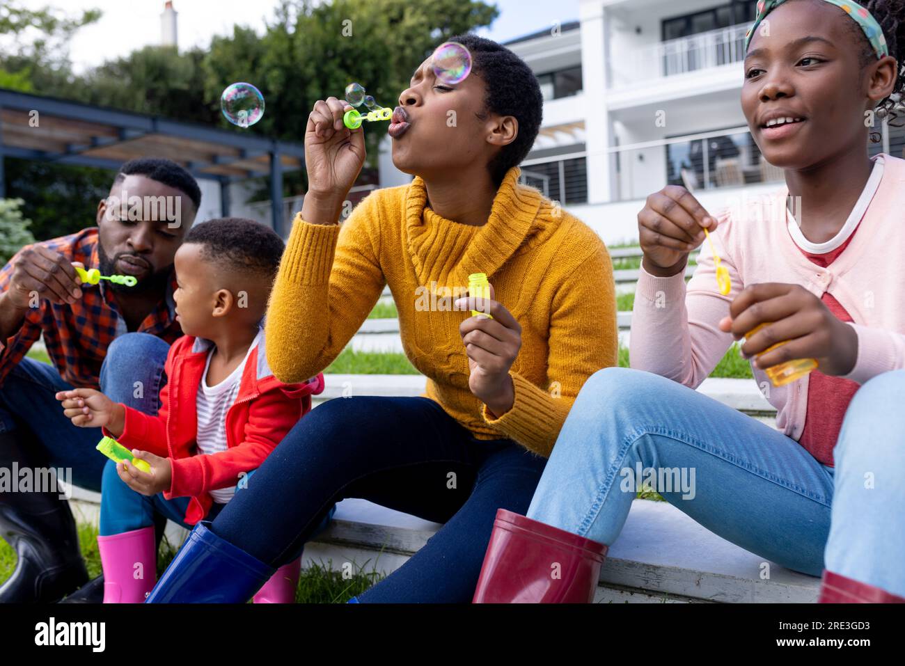 Couple afro-américain avec fils et fille soufflant des bulles dans le jardin à la maison Banque D'Images