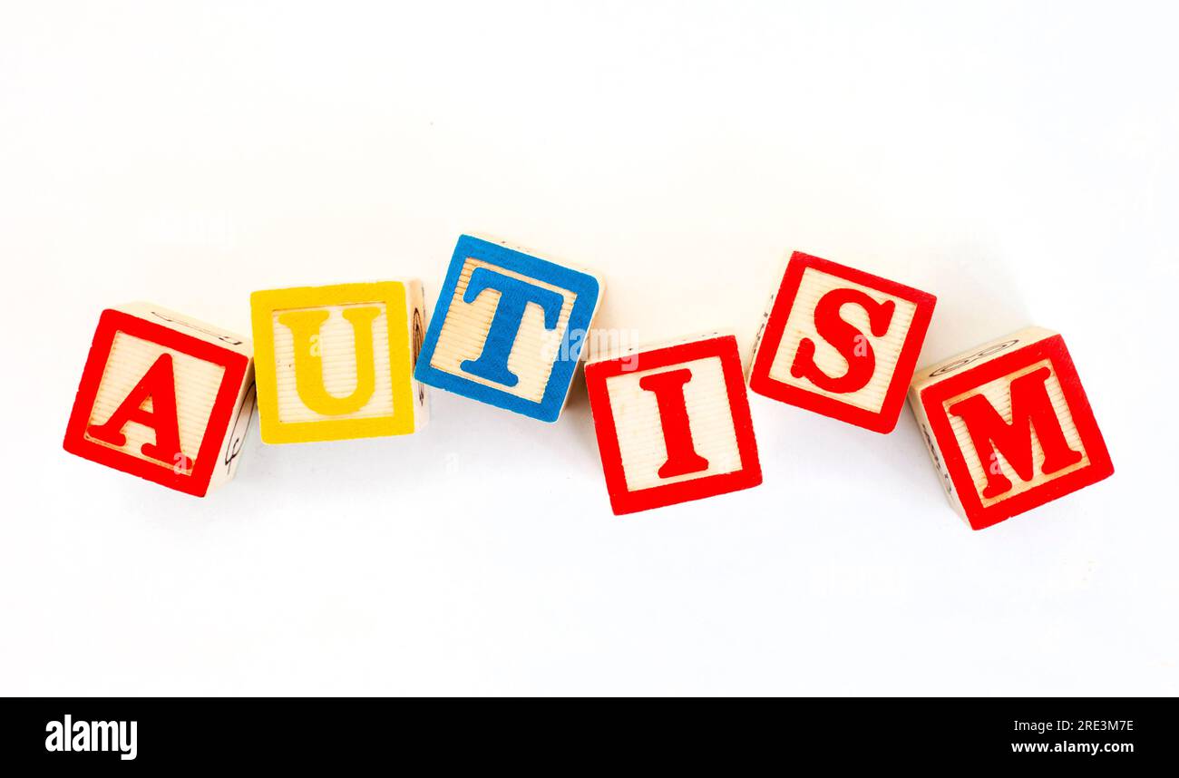 Autisme épelé dans les blocs de construction des enfants sur fond blanc ordinaire. Banque D'Images