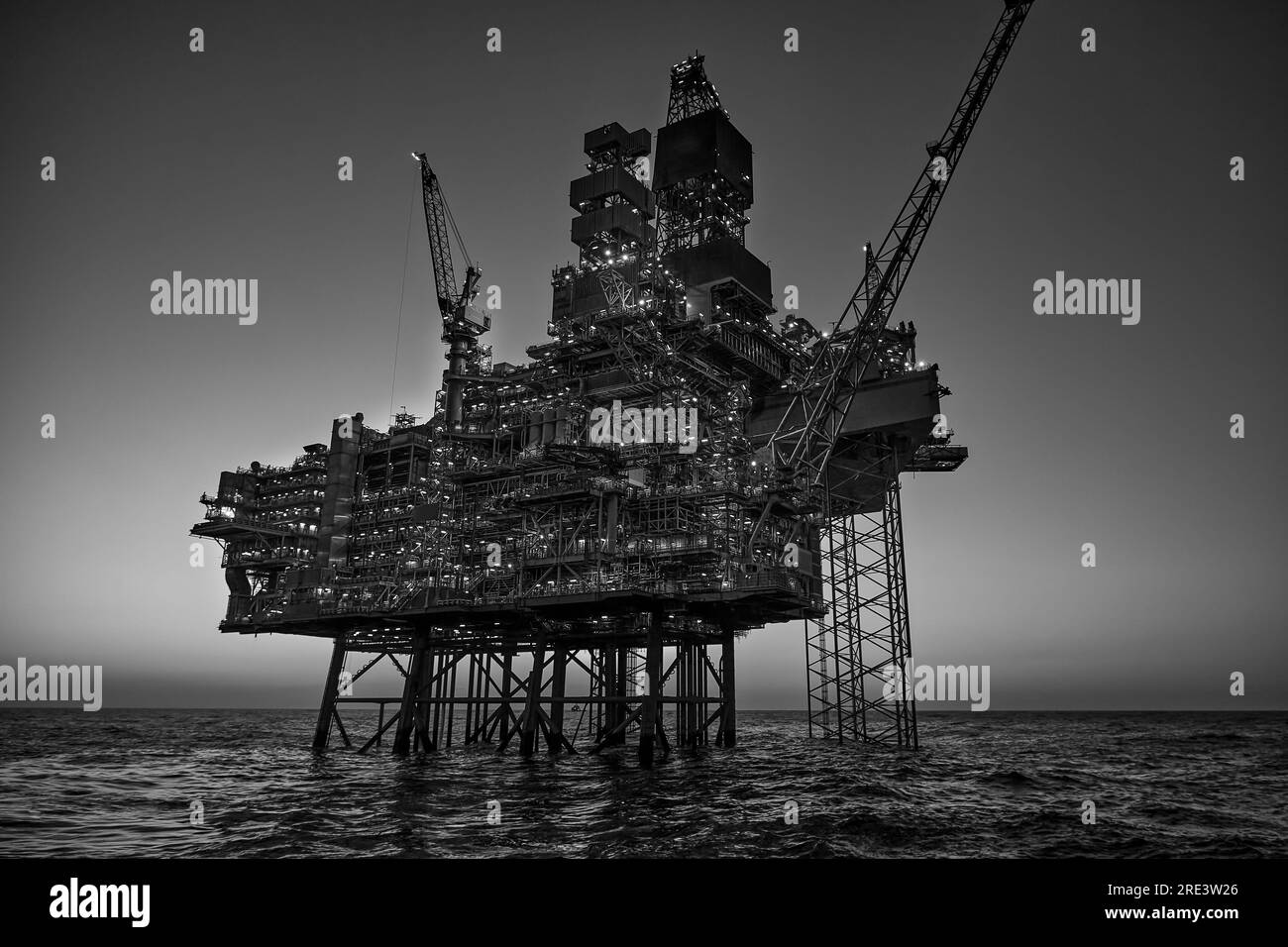 Jack up plate-forme pétrolière dans la mer au coucher du soleil. Banque D'Images