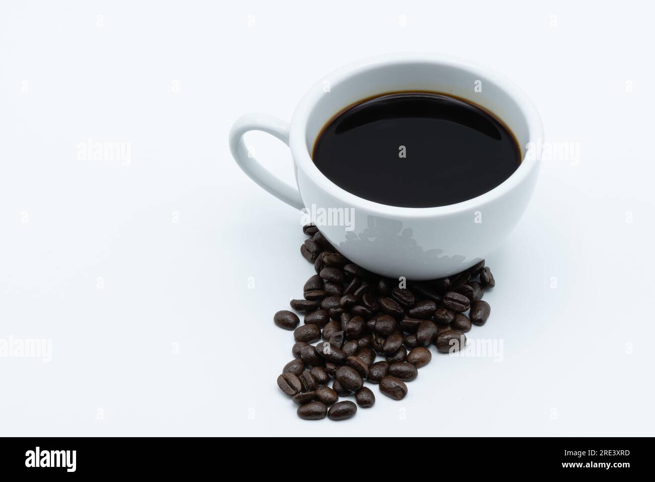 Café noir dans une tasse en céramique sur fond blanc Banque D'Images