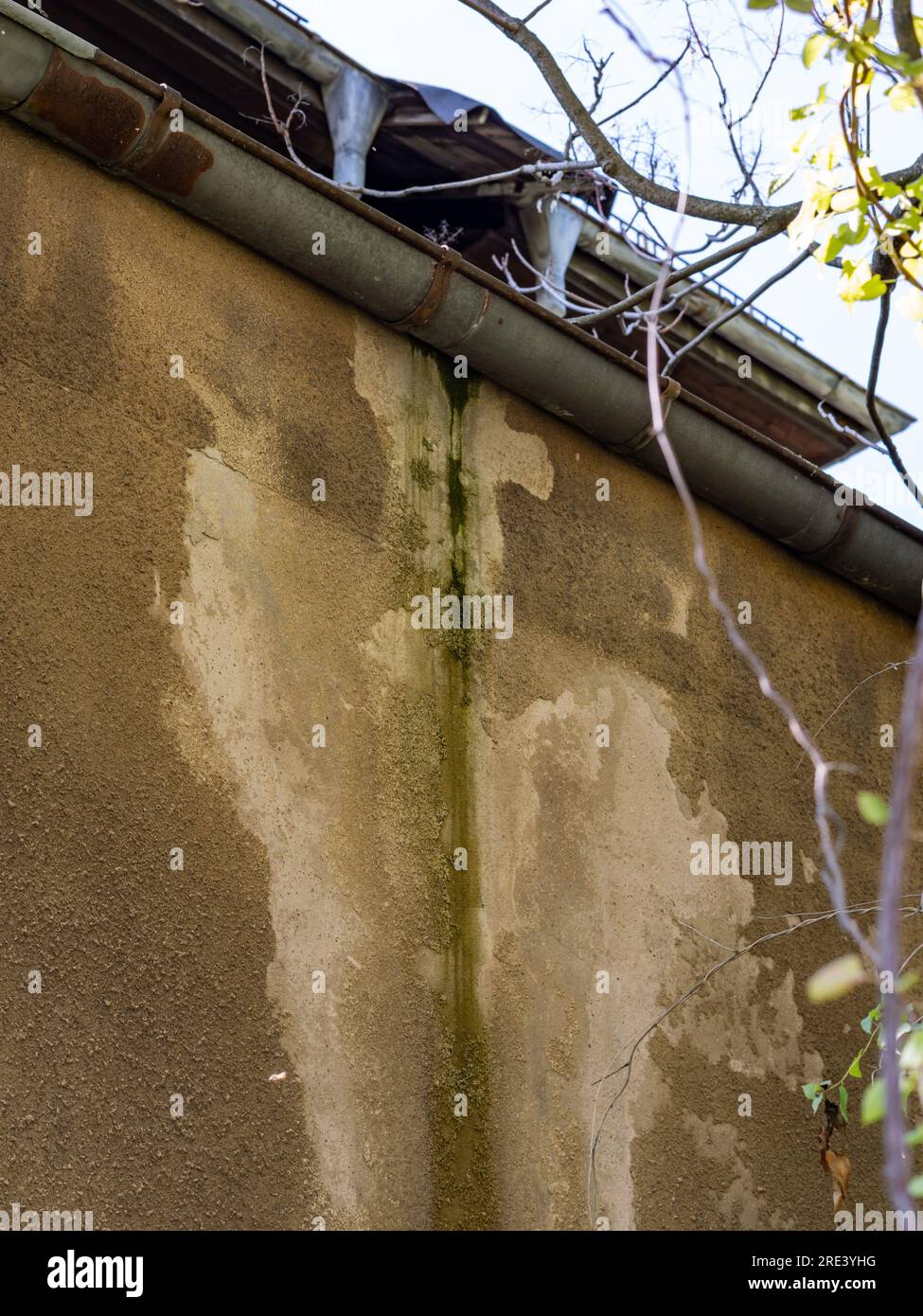 Dégâts d'eau sur la façade d'un bâtiment causés par la gouttière du toit. Une fuite dans le toit a mouillé le plâtre mural jusqu'à ce qu'il tombe. Banque D'Images