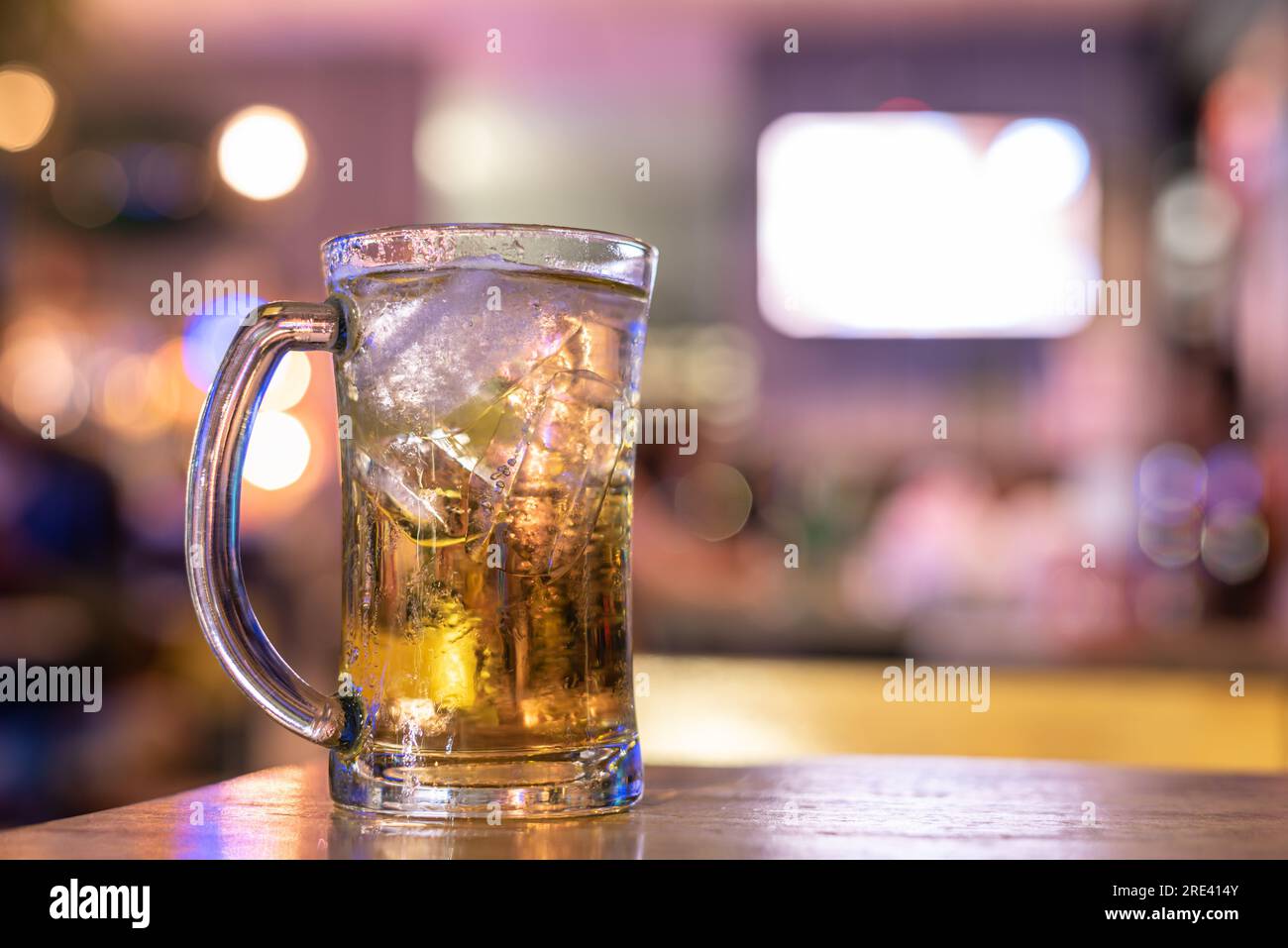 Un verre de bière sur une table en bois dans un café avec fond bokeh Banque D'Images