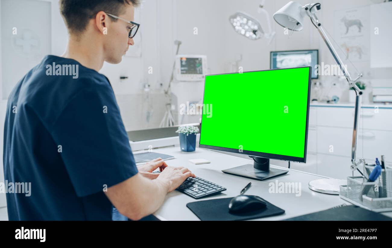 Vétérinaires féminins et masculins effectuant des contrôles de santé UPS sur un animal de compagnie en visite. Vétérinaire professionnel dans une clinique vétérinaire moderne utilisant des moniteurs à écran vert Banque D'Images