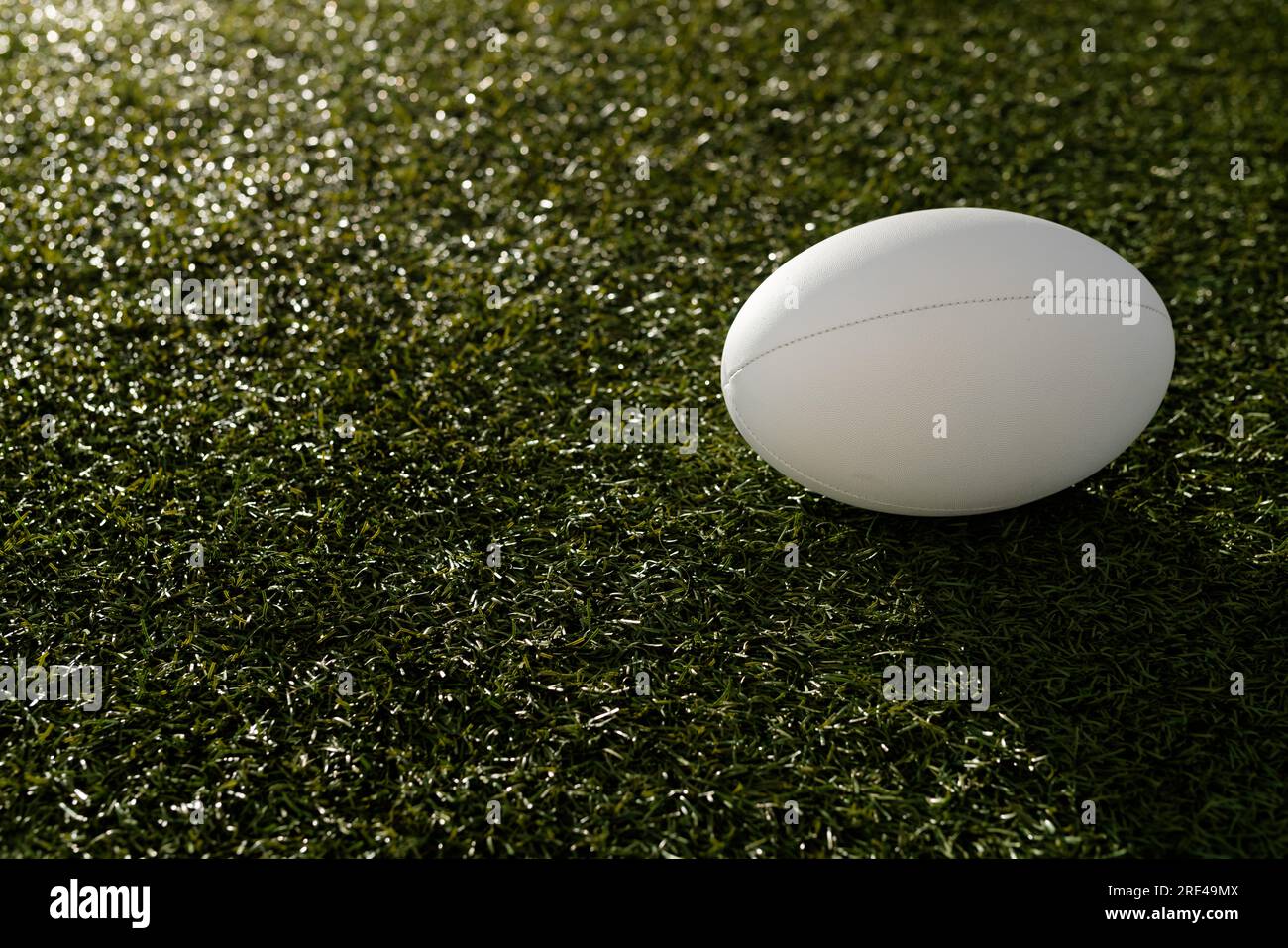 Ballon de rugby blanc sur herbe avec espace de copie, au ralenti Banque D'Images