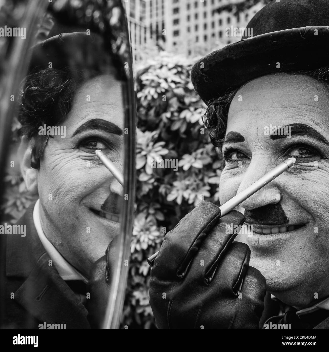 Charlie Chaplin applique le maquillage comme il se prépare pour la journée de divertissement de rue. Banque D'Images