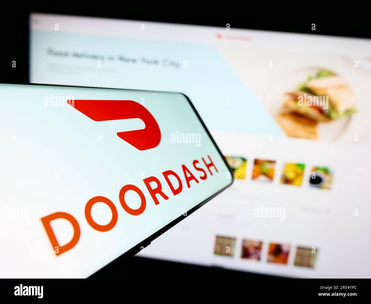 Téléphone mobile avec logo de la société américaine de livraison de nourriture Doordash Inc. Sur l'écran en face du site Web. Concentrez-vous sur le centre-droit de l'écran du téléphone. Banque D'Images