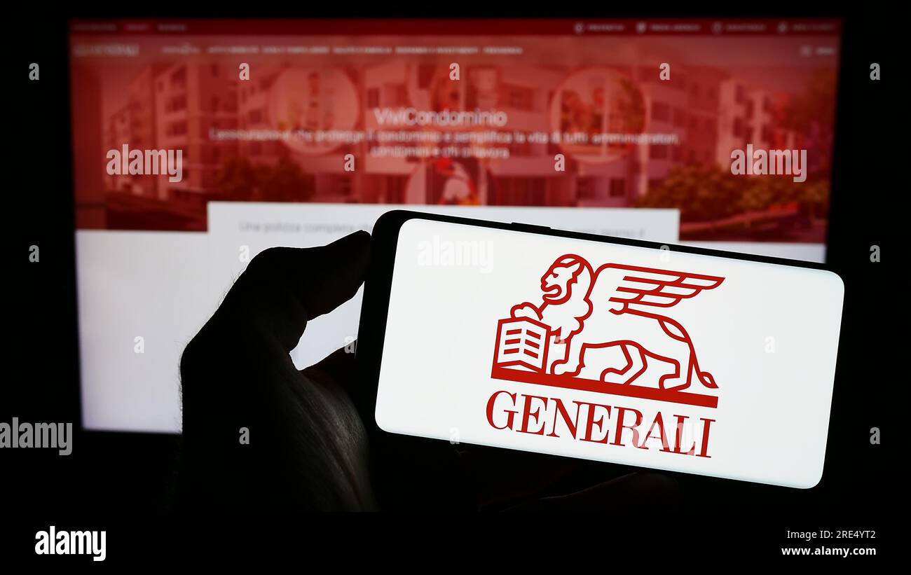 Personne tenant le téléphone portable avec le logo de la compagnie d'assurance Assicurazioni Generali spa sur l'écran en face de la page Web. Concentrez-vous sur l'affichage du téléphone. Banque D'Images