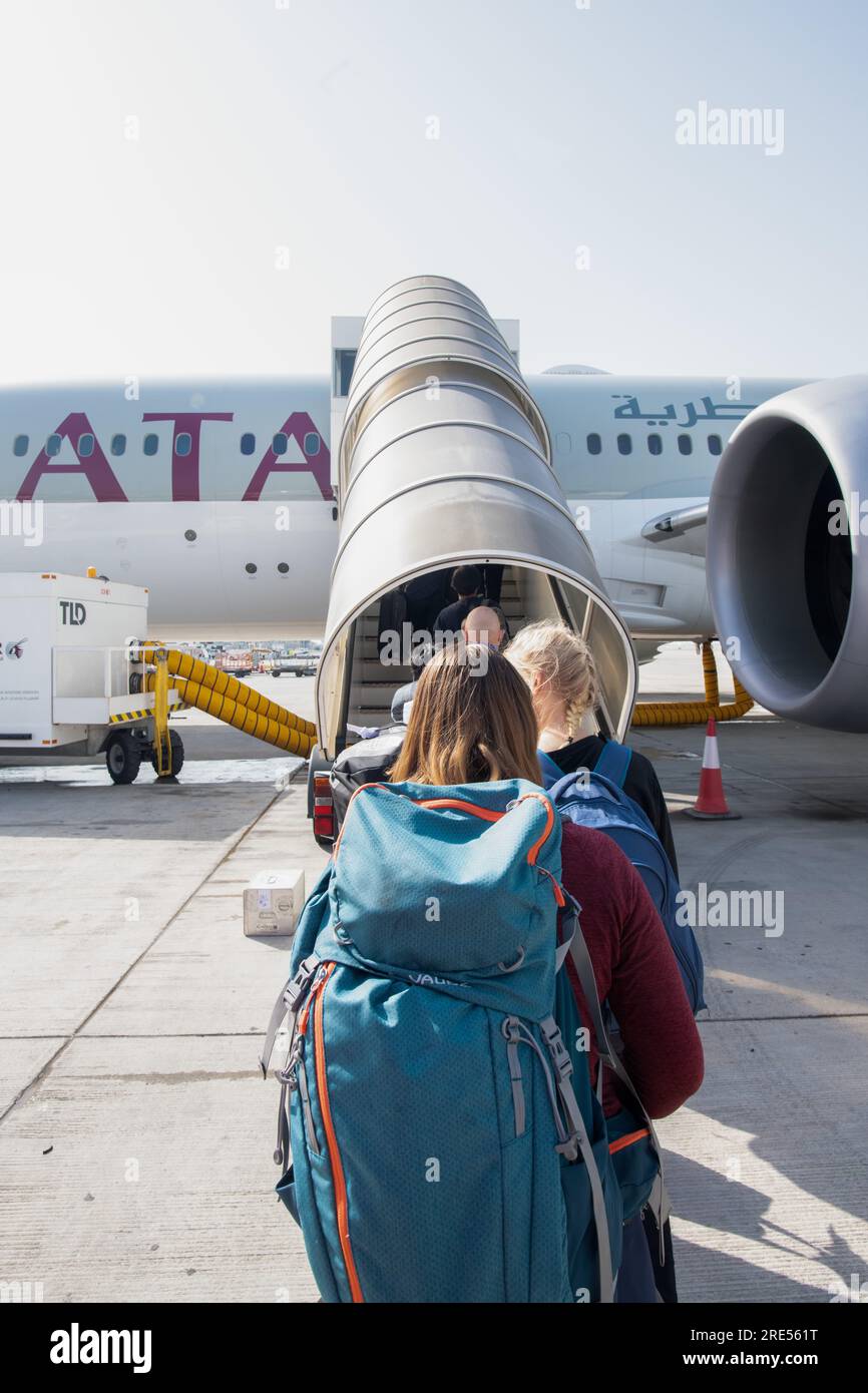 Passagers avec des bagages entrant dans l'avion de la compagnie aérienne Qatar à l'aéroport de Doha Banque D'Images