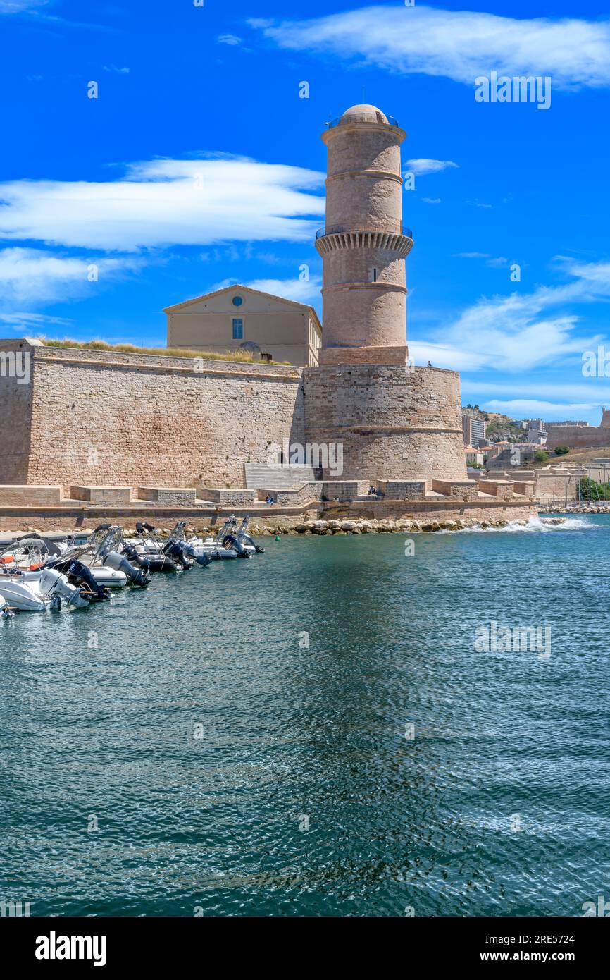 Des rangées de hors-bord amarrées ferment la ville de Marseille. Derrière se trouve la tour de pierre de la Tour du Fanal, construite en 1644 pour guider les navires dans le vieux port. Banque D'Images