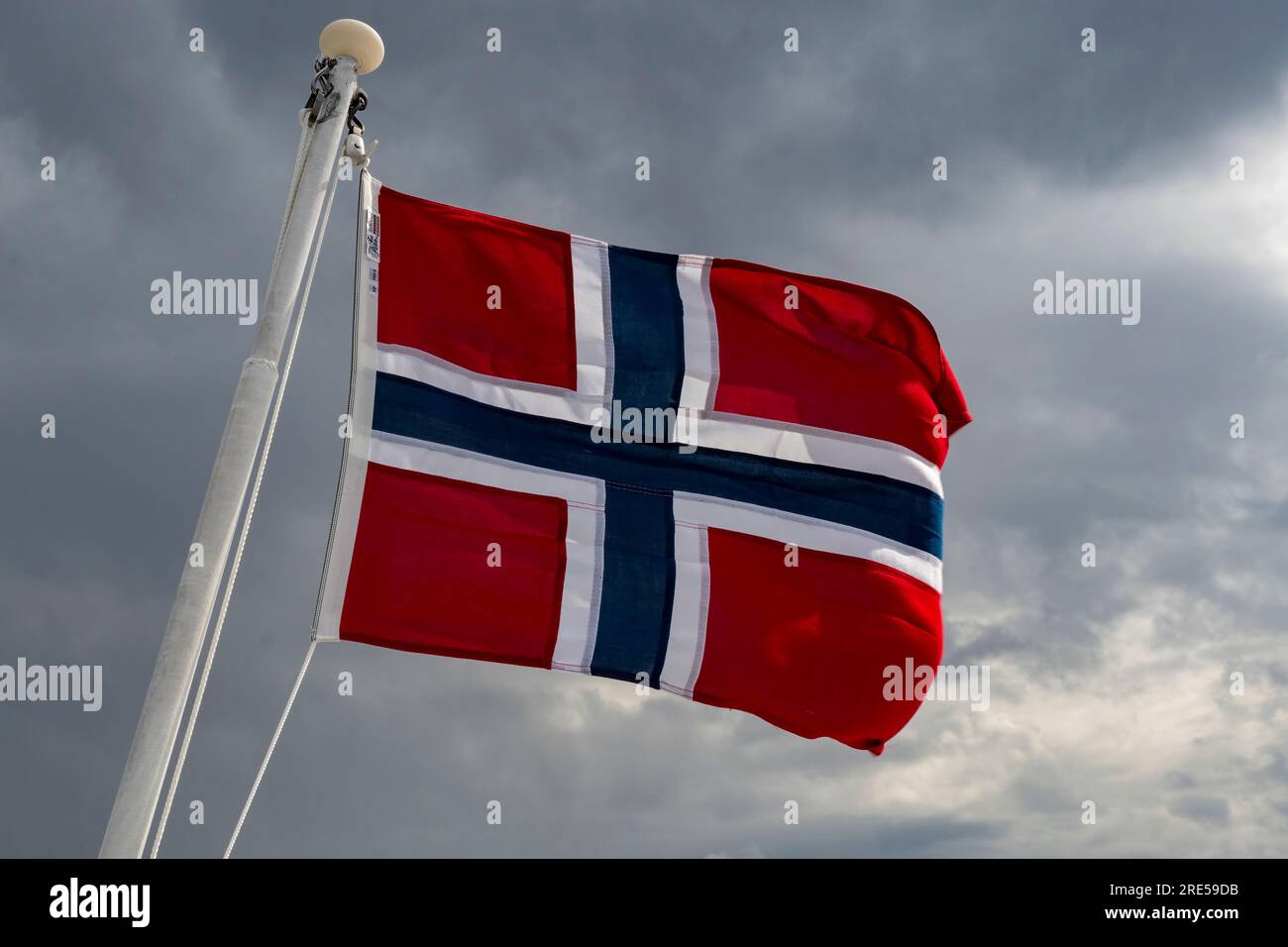 Drapeau norvégien soufflant dans le vent fort contre le ciel de mauvaise humeur Banque D'Images