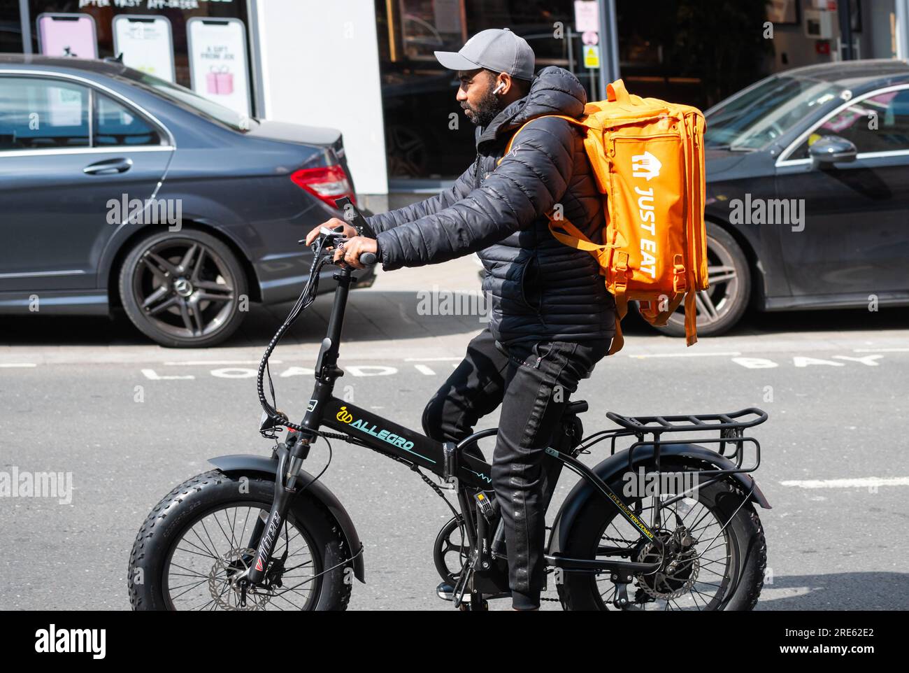 Cycliste roulant à vélo livrant de la nourriture pour Just Eat à Brighton & Hove, East Sussex, Angleterre, Royaume-Uni. Banque D'Images
