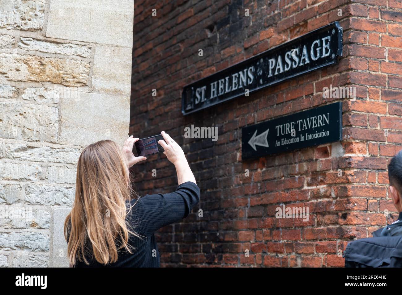 Touriste féminine prenant la photo de St Helen passage, Oxford, menant à Turf Tavern. Banque D'Images