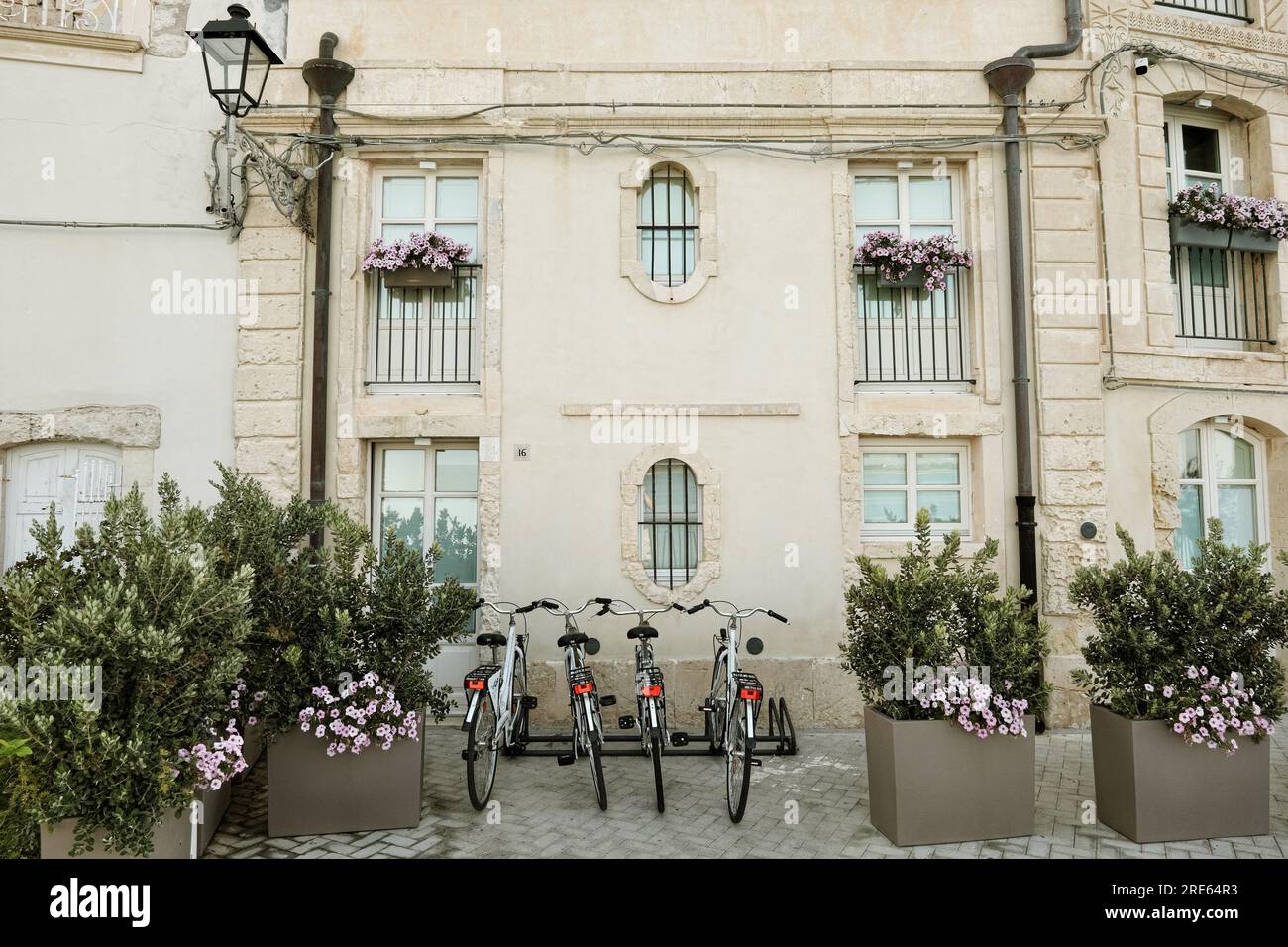 Vélos devant une belle façade de vieille maison ornée de fleurs à Ortigia, Syracuse, Sicile, Italie Banque D'Images