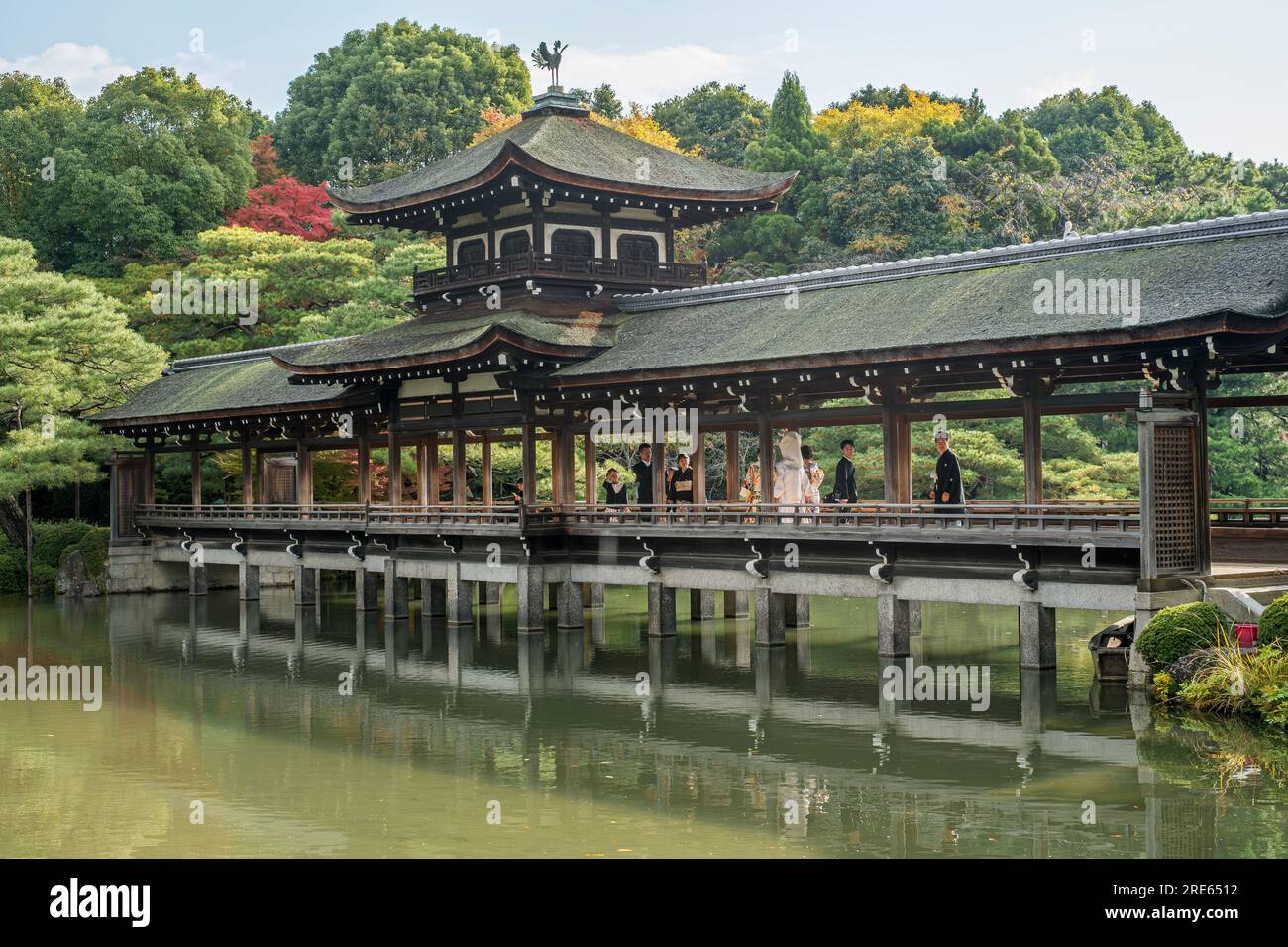 Une fête de mariage sur un pont au-dessus d'un étang à Heian Jingu, un sanctuaire shinto à Kyoto, Japon. Banque D'Images