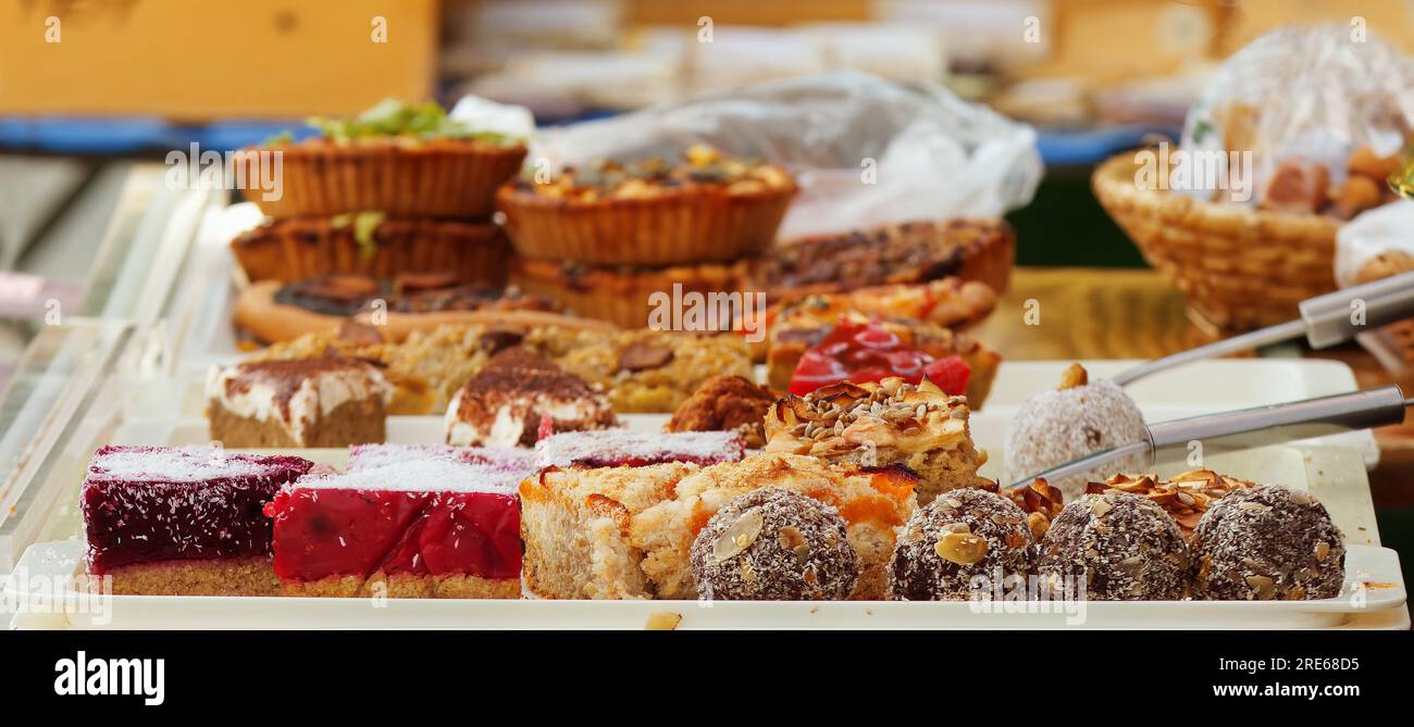 Stand de confiserie avec une variété de desserts, boules de punch enrobées de noix de coco râpée, brownies saupoudrées d'amandes et graines de pavot tourbillonnent à l'avant Banque D'Images