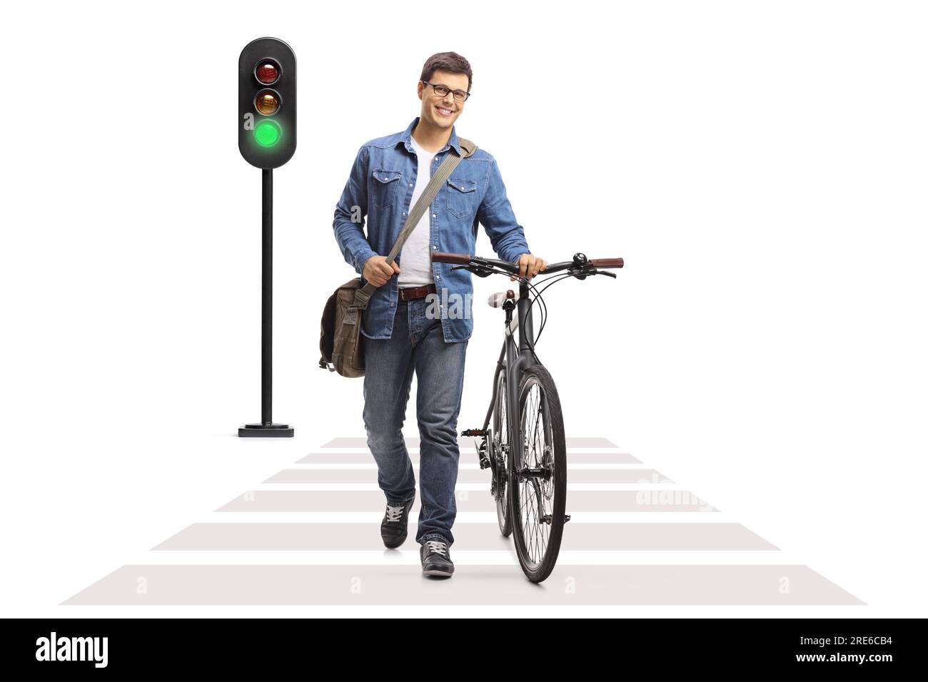 Portrait en longueur d'un homme marchant et poussant un vélo à un passage piéton isolé sur fond blanc Banque D'Images