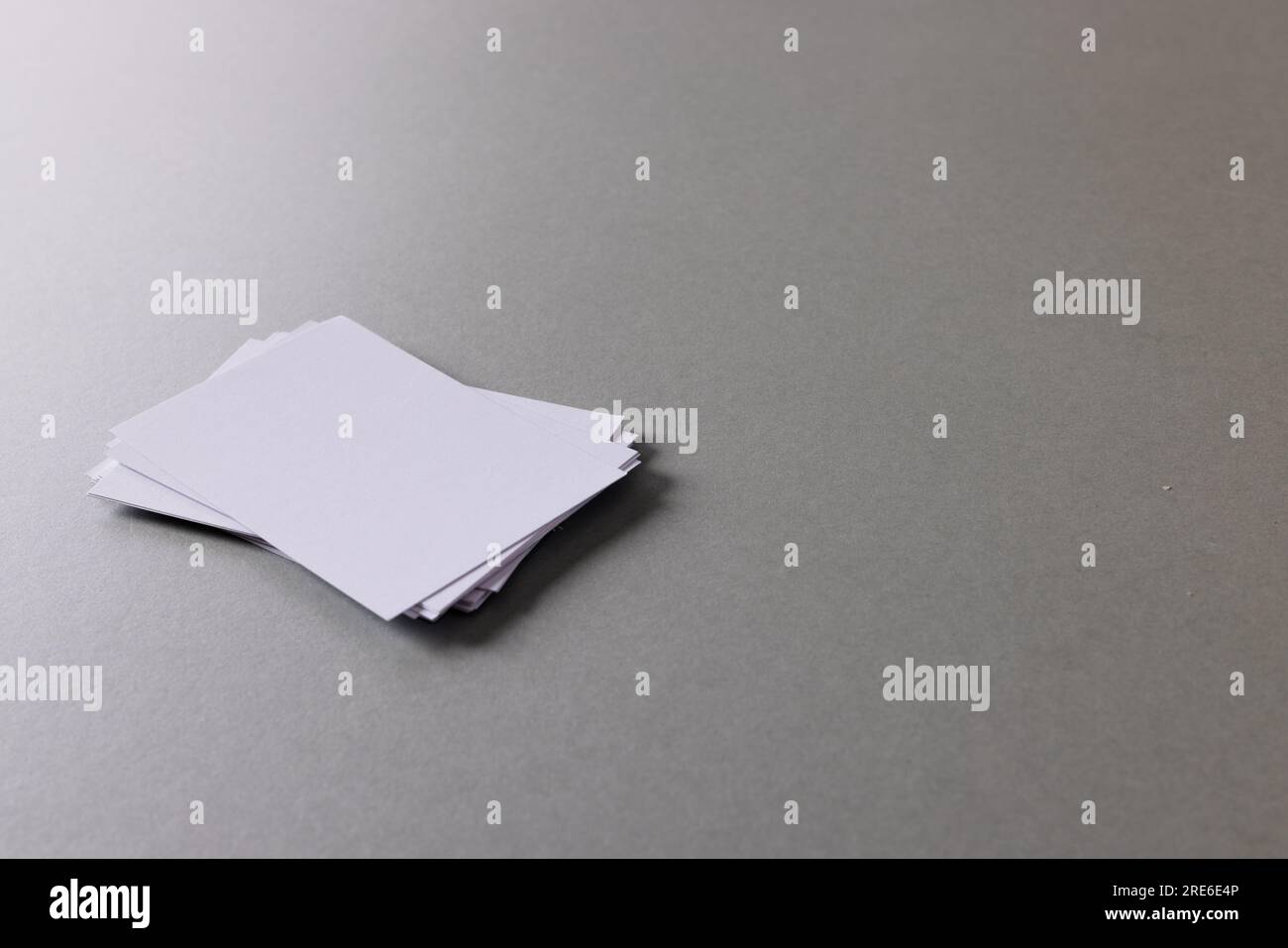 Pile de cartes de visite blanches avec espace de copie sur fond gris Banque D'Images