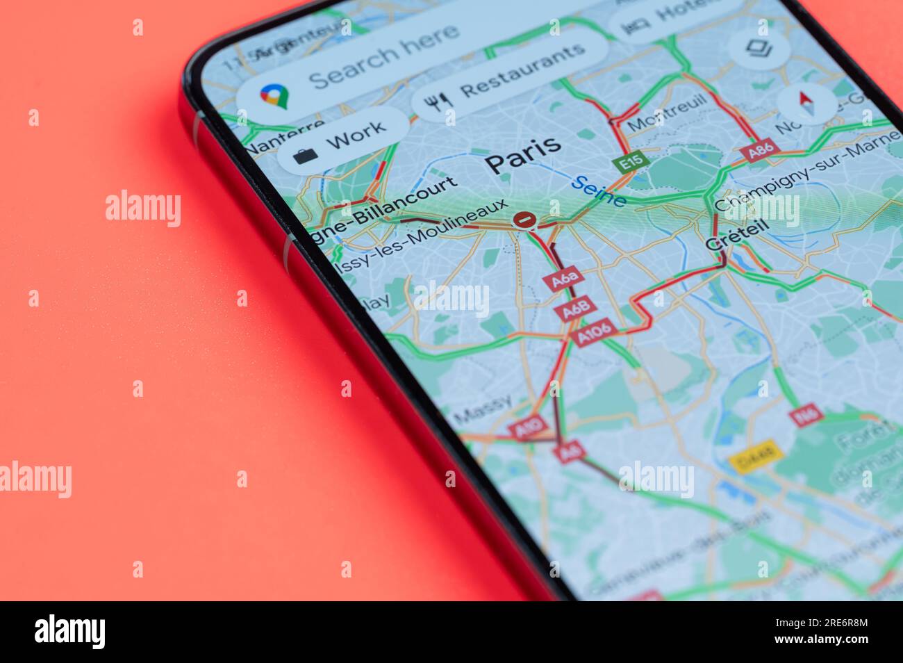 New York, USA - 21 juillet 2023 : carte des embouteillages à Paris sur écran smartphone vue rapprochée avec fond rouge Banque D'Images