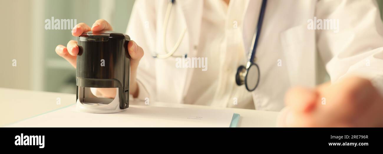 Un médecin appose un timbre sur les documents médicaux importants Banque D'Images